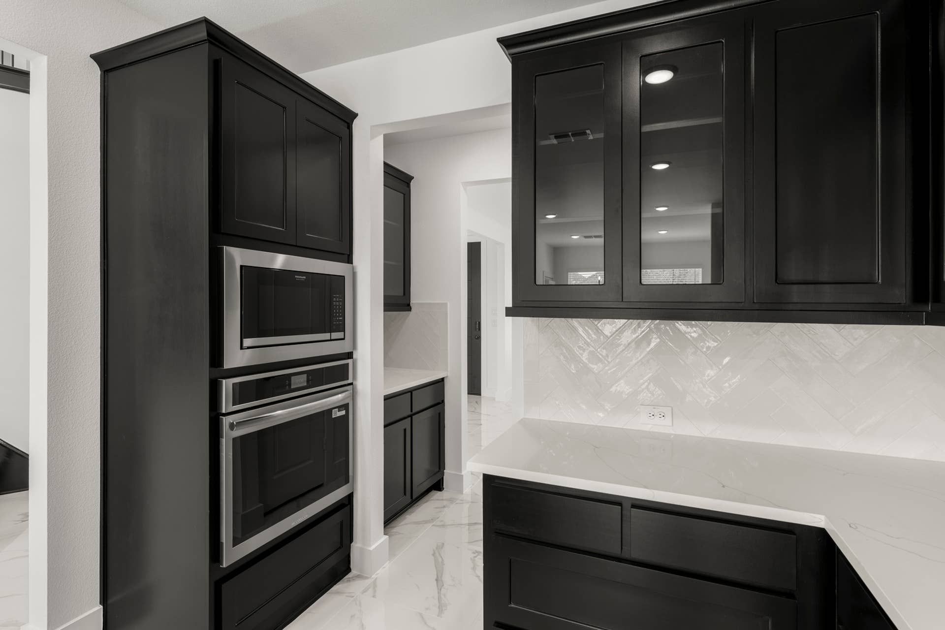 Sleek modern kitchen with dark cabinetry and stainless steel appliances.