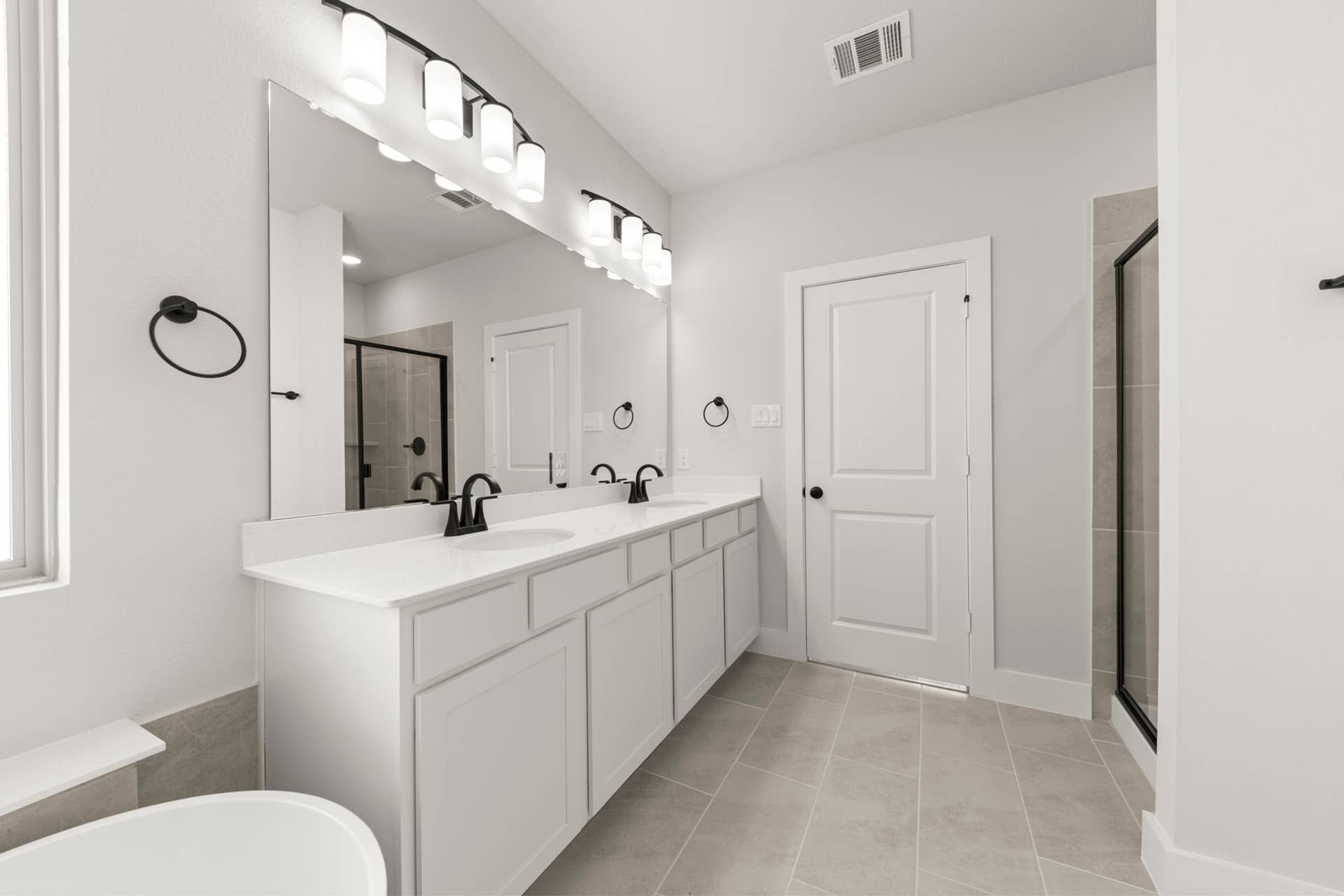 Modern bathroom with double vanity and sleek black fixtures.