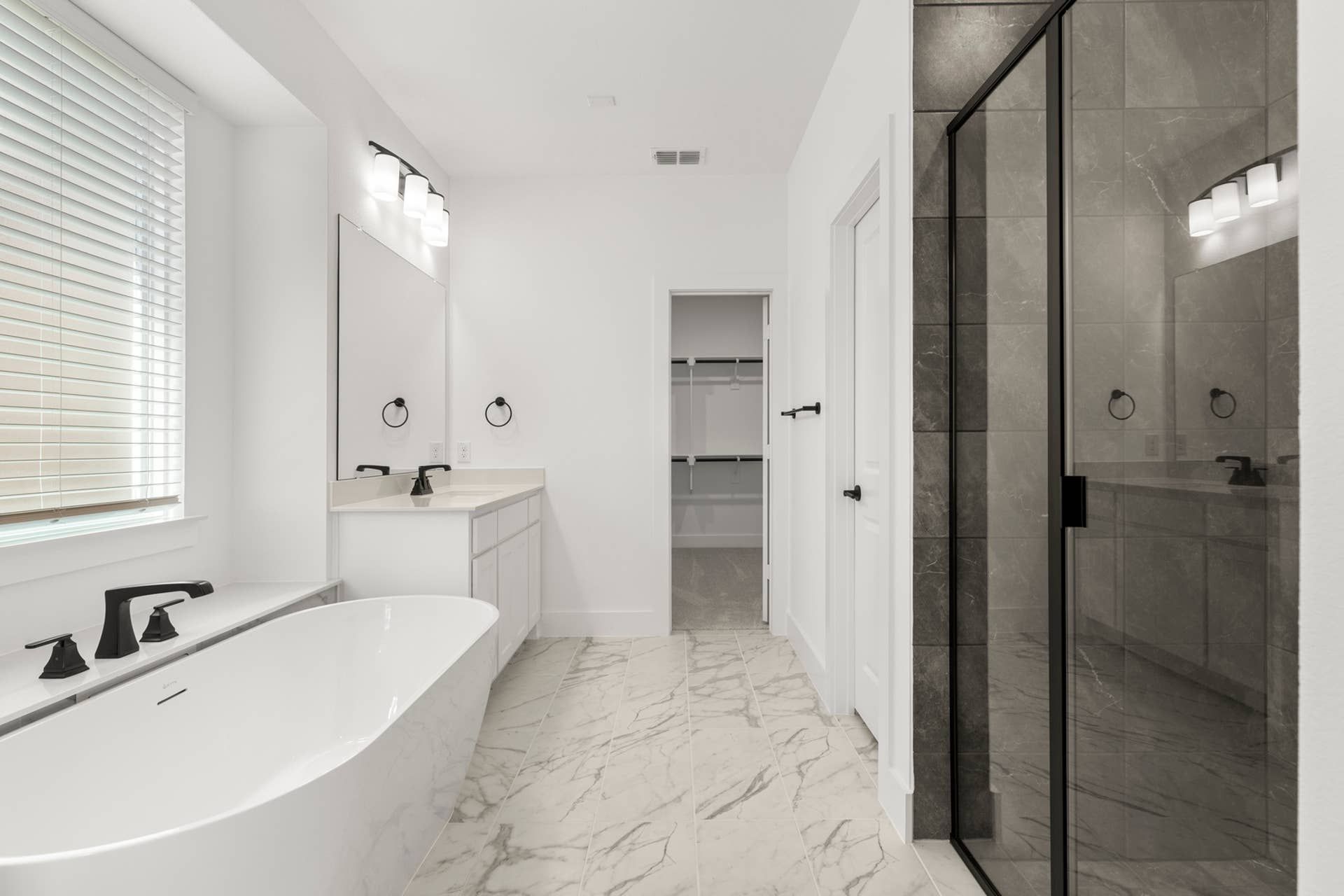 Modern bathroom with freestanding tub, glass shower, and dual vanity.