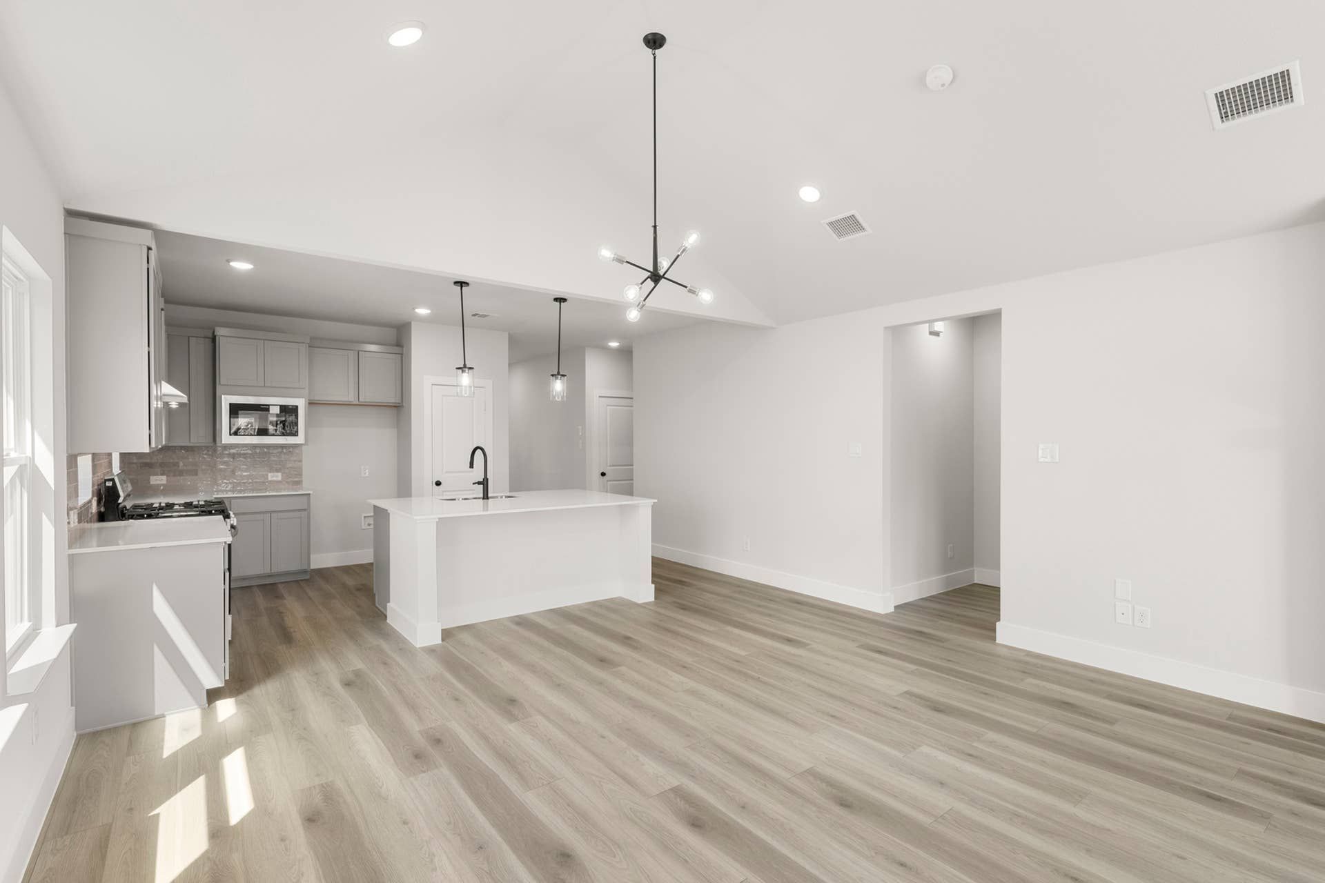 Modern kitchen and dining area with sleek island and recessed lighting.