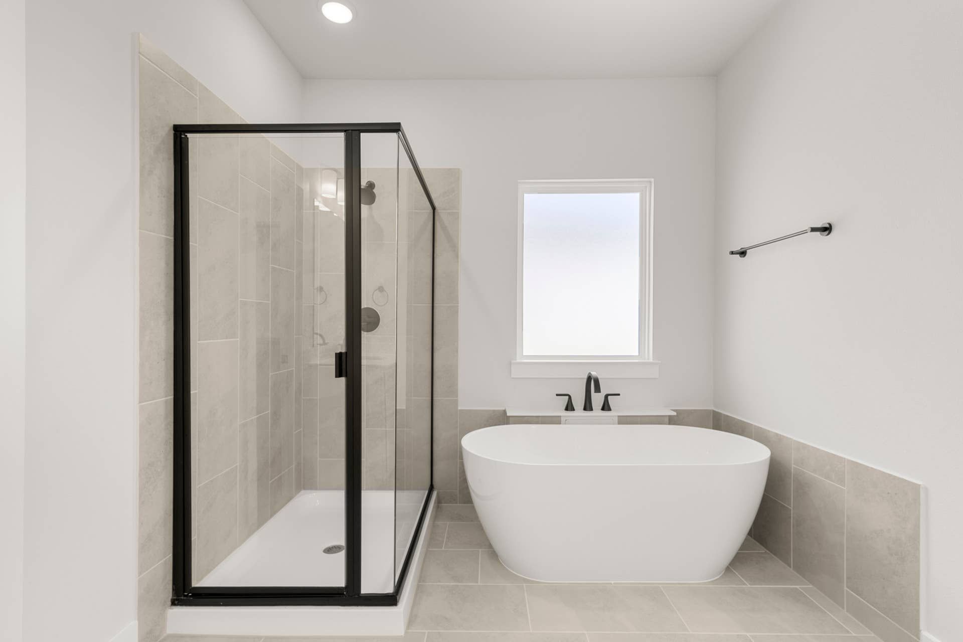 Modern bathroom with freestanding tub and glass-enclosed shower.