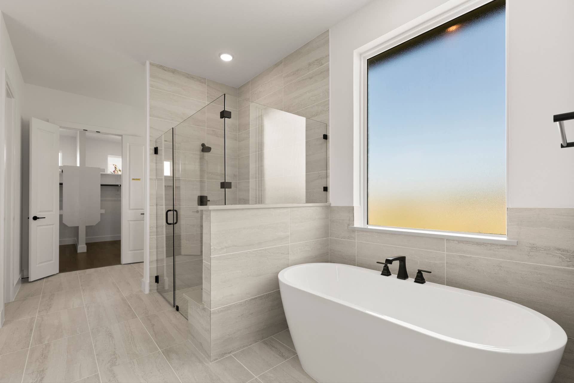 Modern bathroom with freestanding tub and glass-enclosed shower.