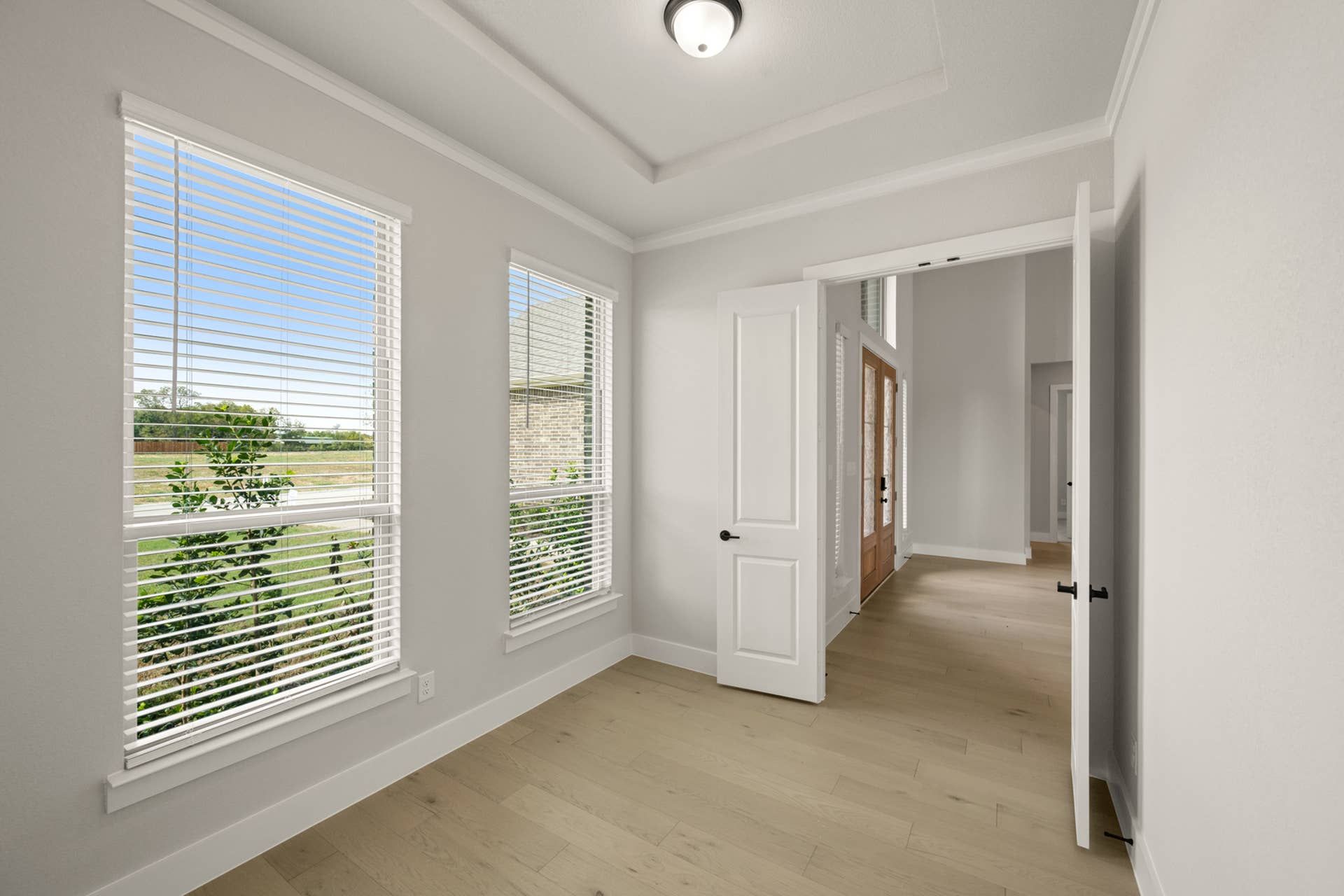 Bright study room with large windows and wooden flooring.