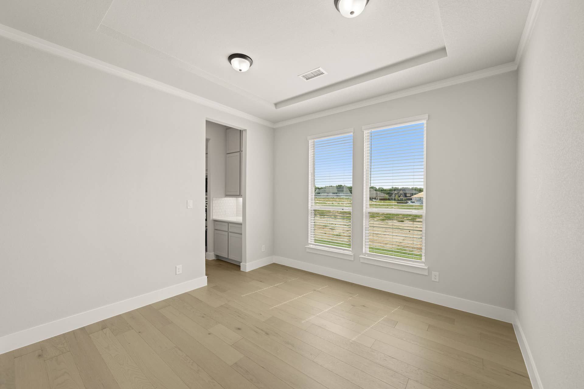Bright dining room with large windows and hardwood floors.