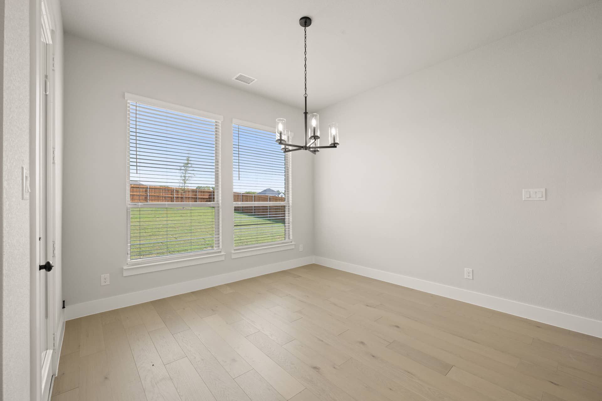 Bright dining nook with hardwood floors and large windows overlooking the yard.