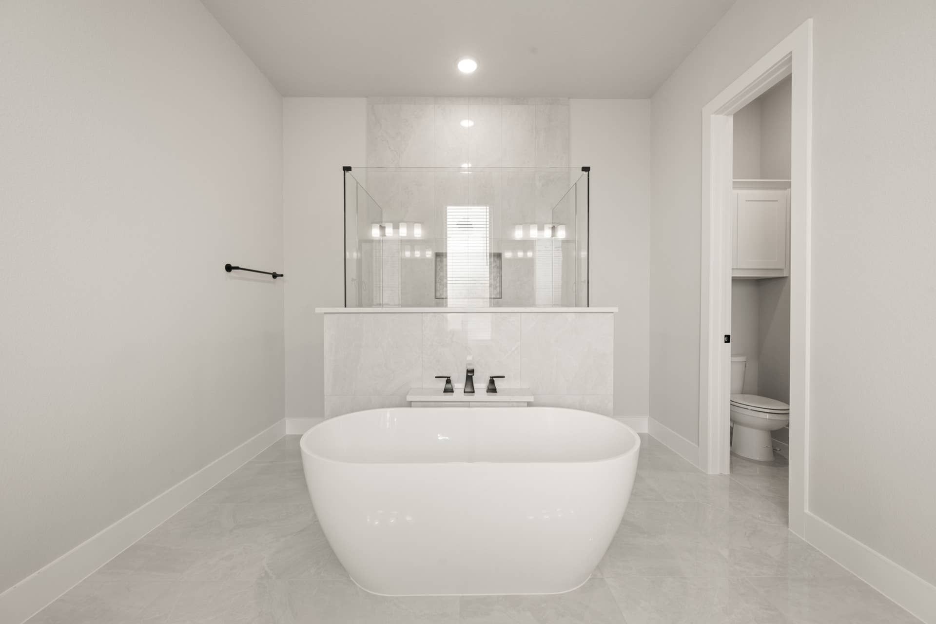 Luxurious bathroom with freestanding tub and glass-enclosed shower.