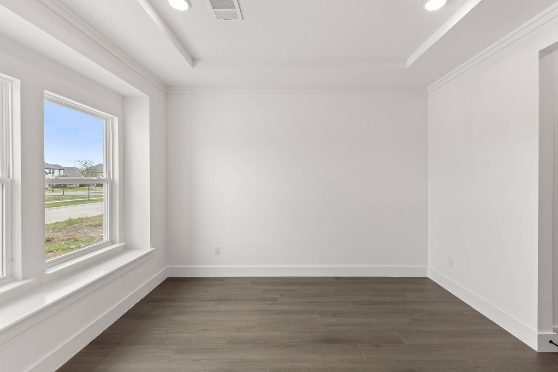 Bright dining room with large windows and hardwood flooring.