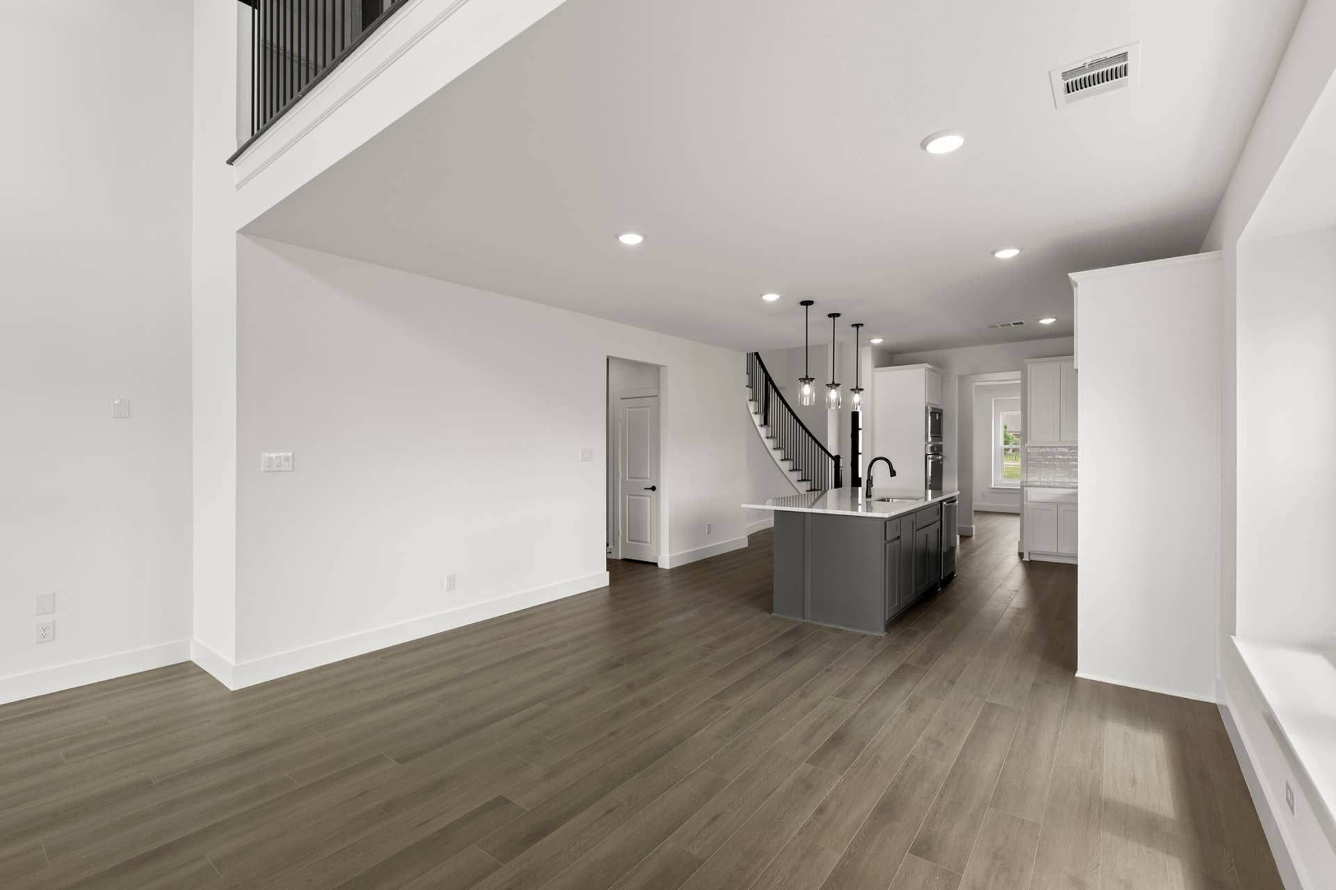 Spacious modern kitchen with island, pendant lighting, and open layout.