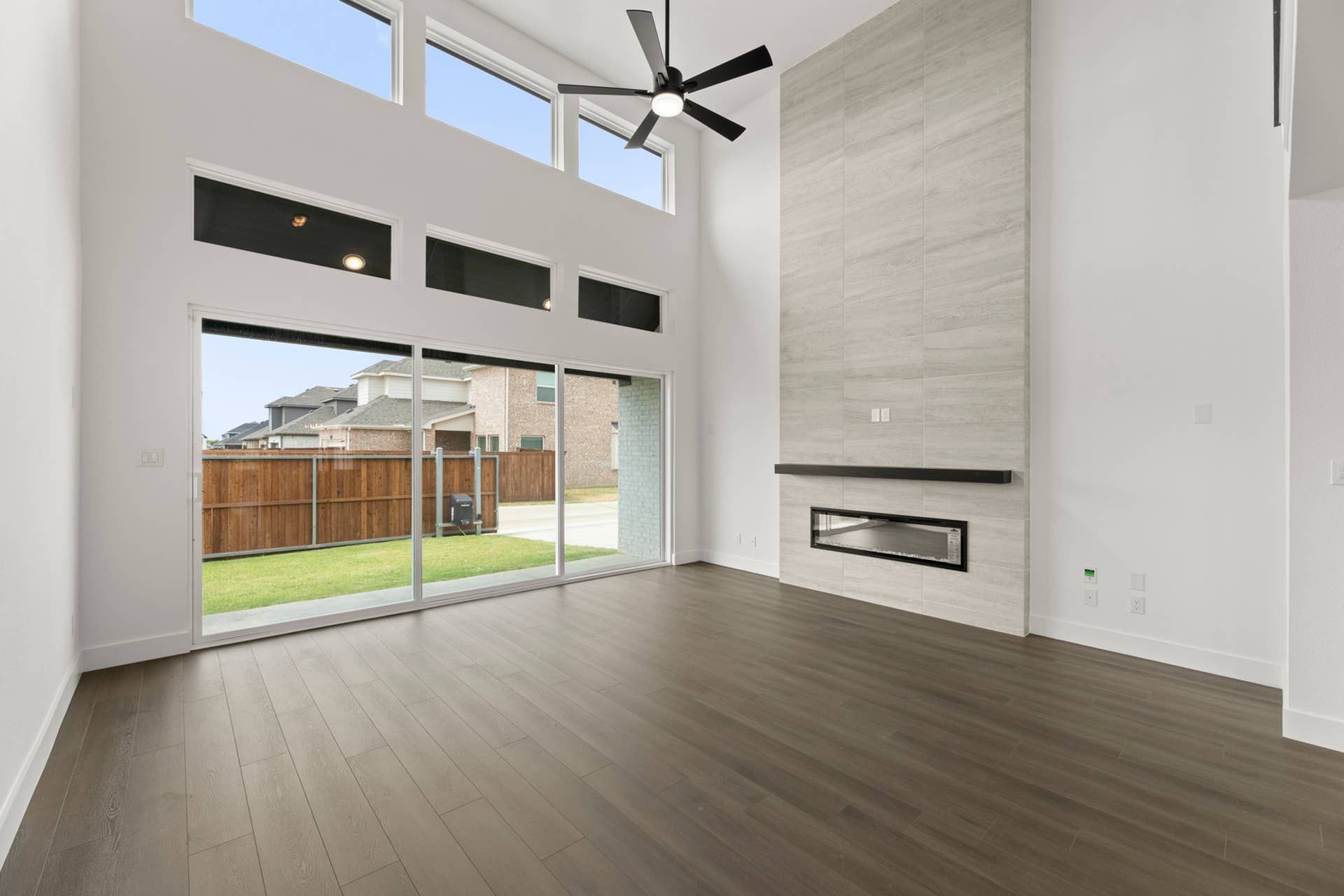 Spacious living room with high ceilings, modern fireplace, and large windows.