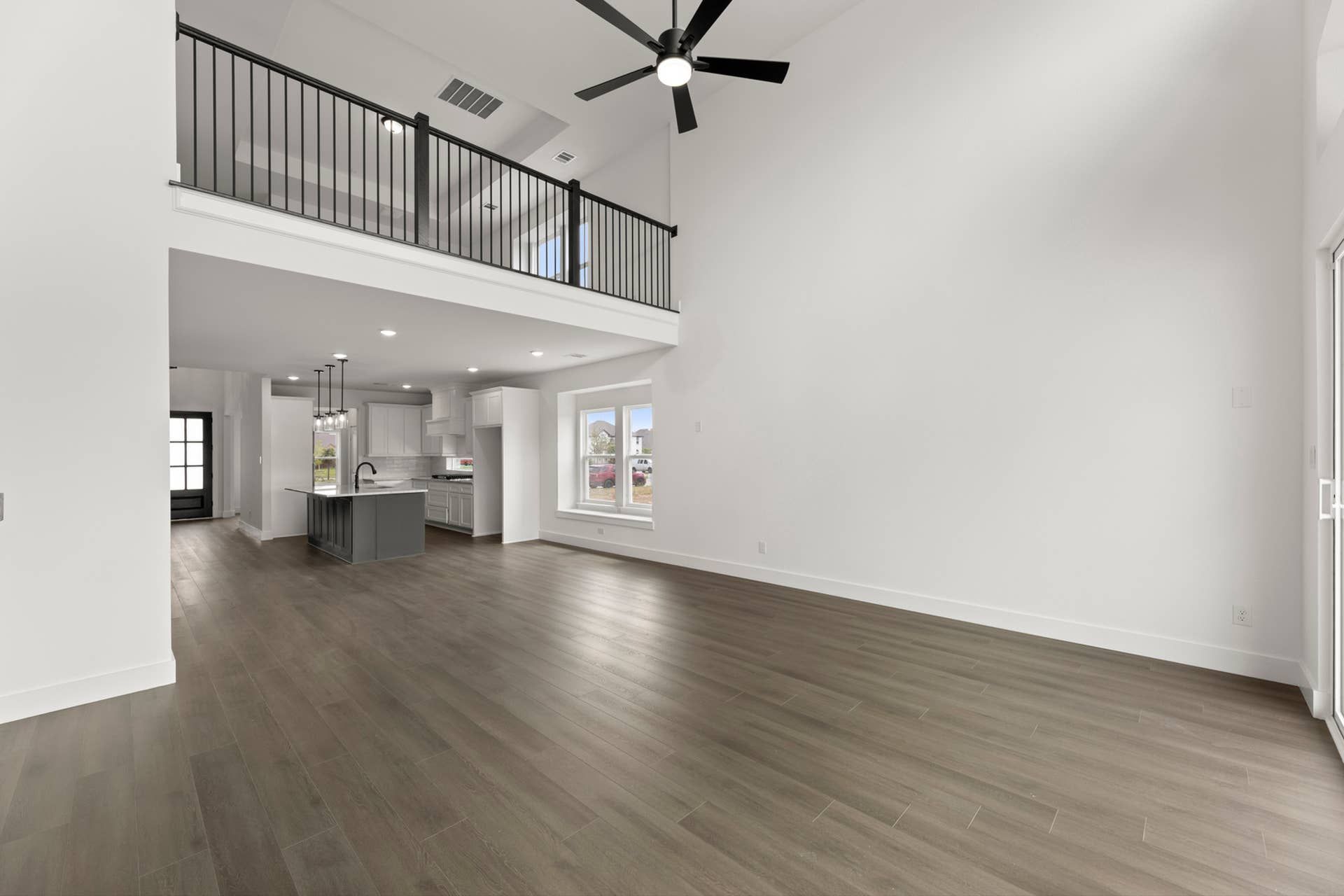 Spacious open-concept interior with high ceilings and modern kitchen view.