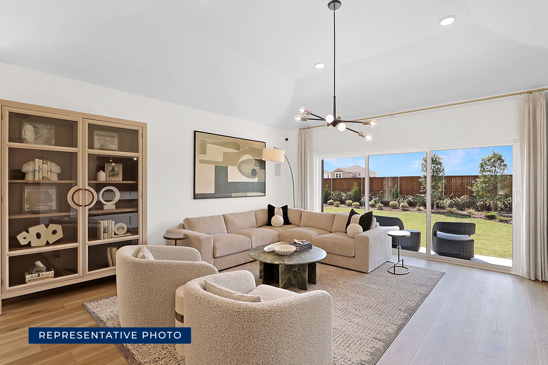 Modern living room with large windows and garden view.