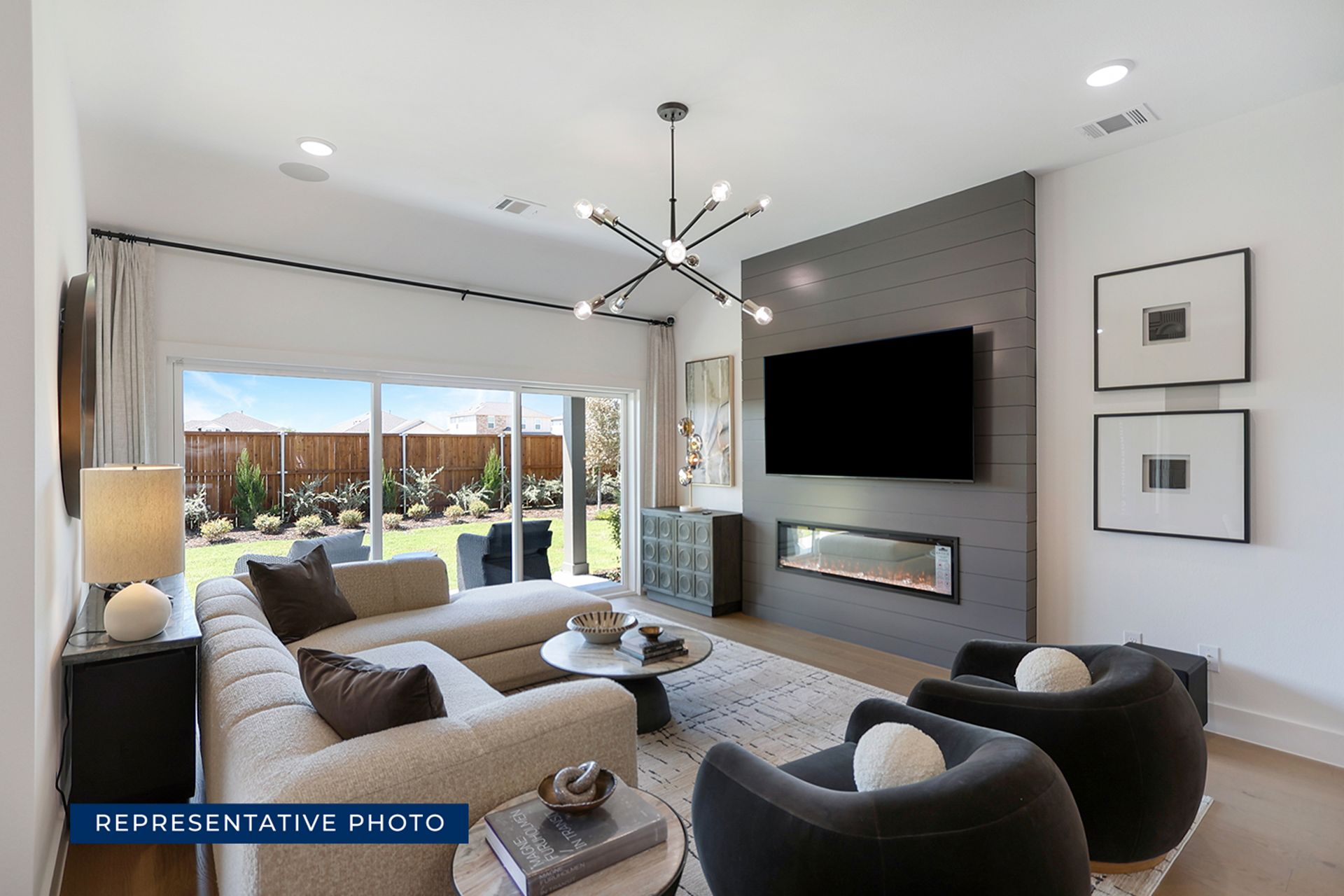 Modern living room with large windows, fireplace, and contemporary furniture.