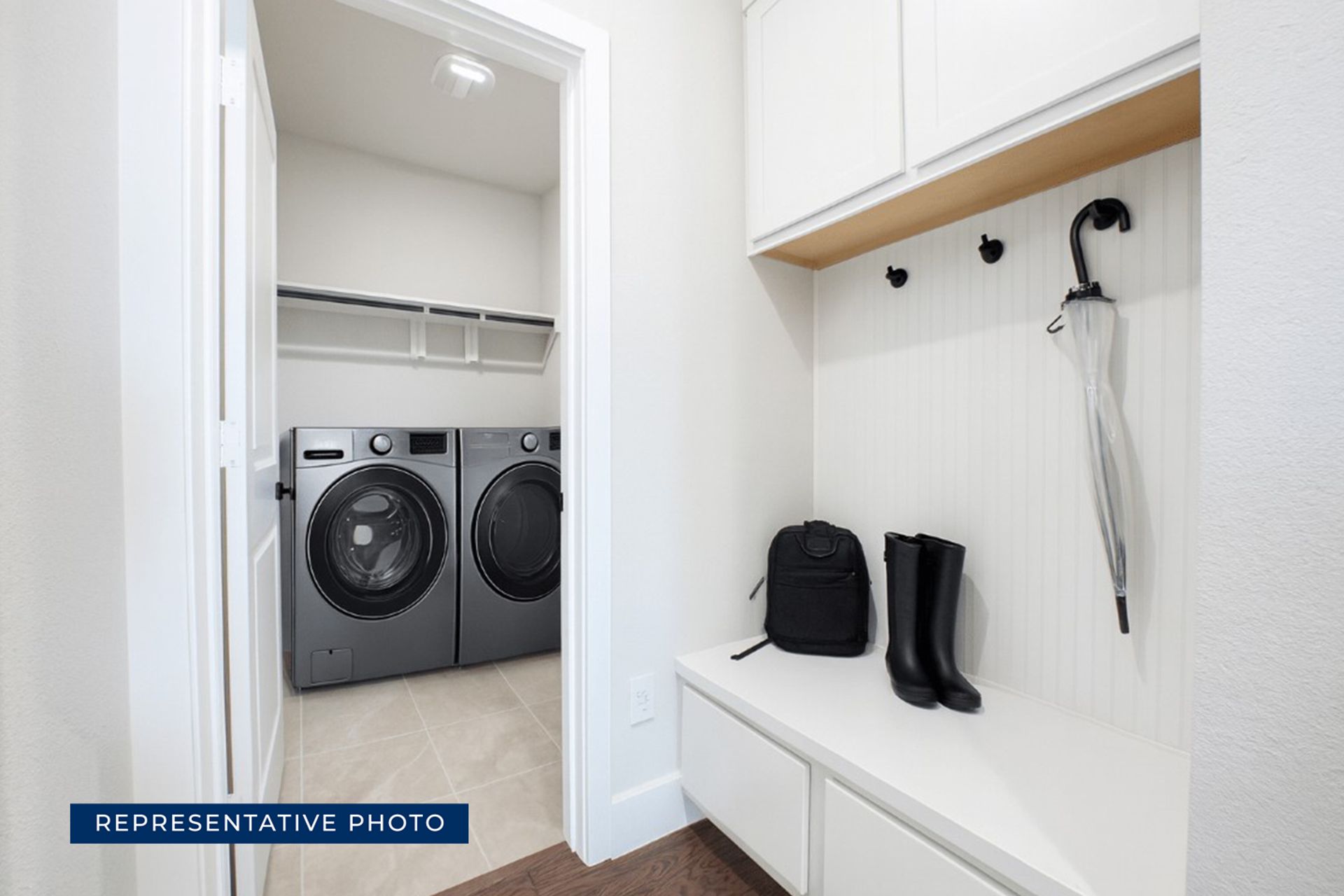 Modern laundry room with washer, dryer, and storage bench.