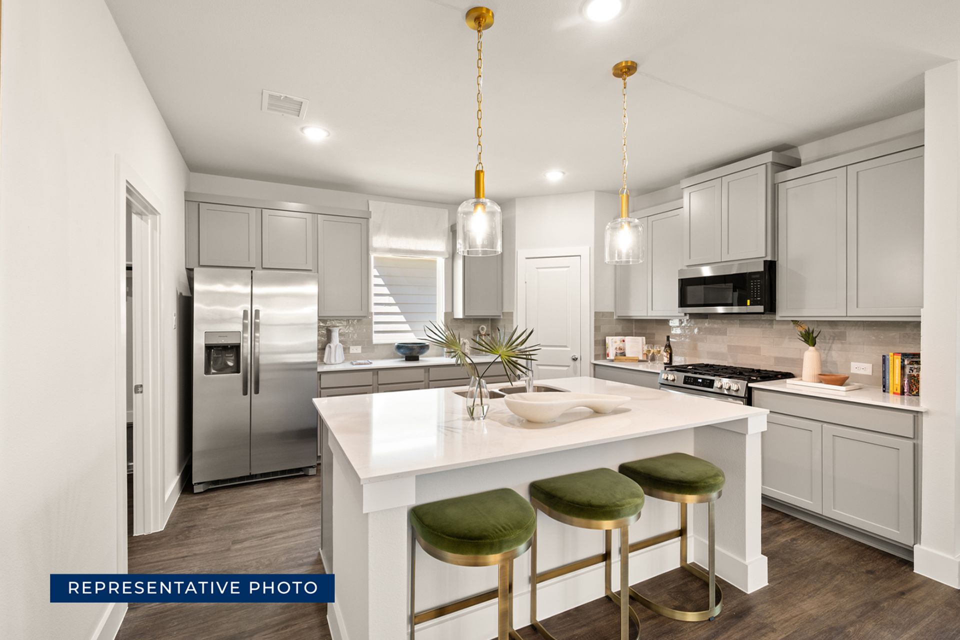 Modern kitchen with gray cabinets, island, and stainless steel appliances.