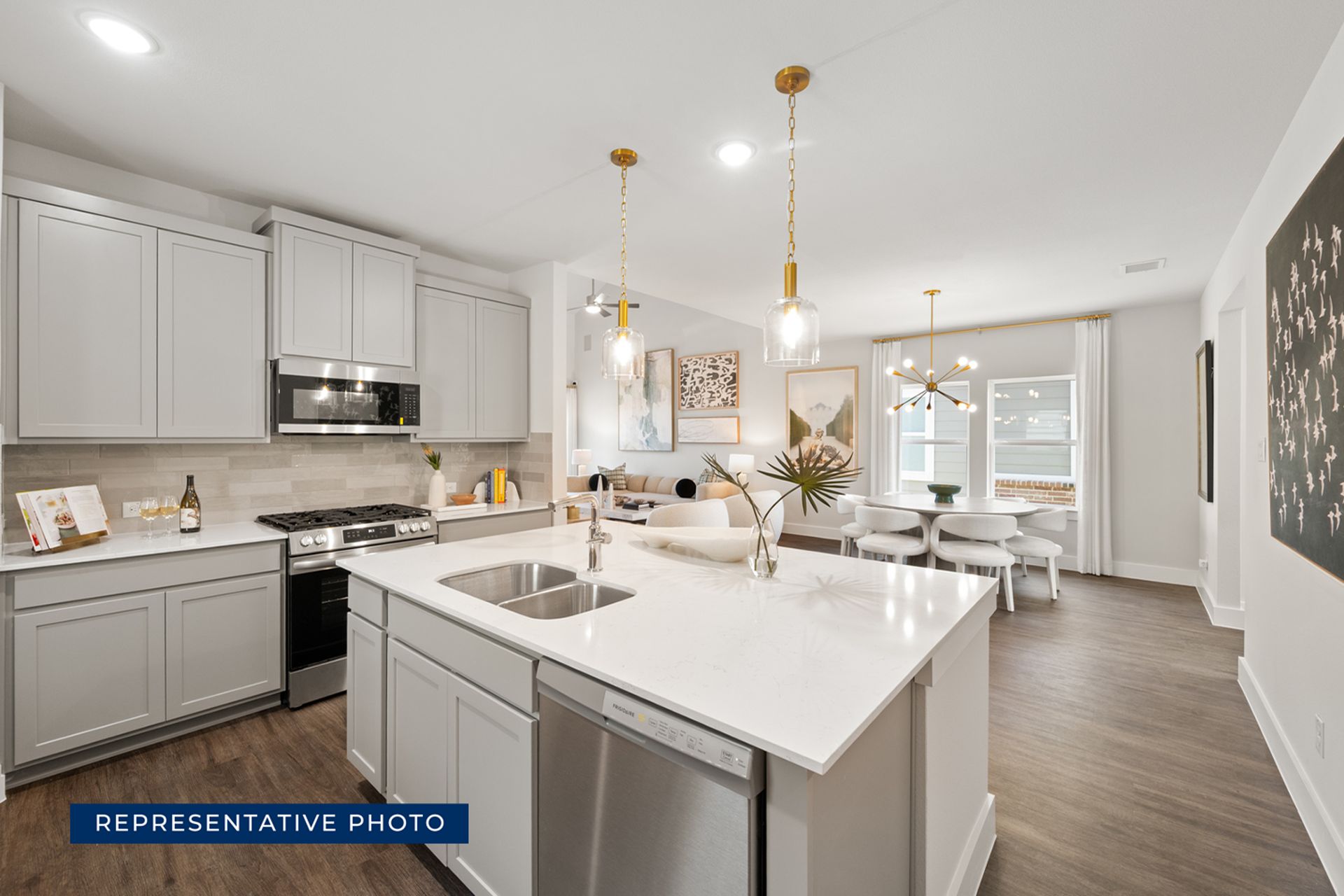 Modern kitchen and dining area with gray cabinets and pendant lighting.