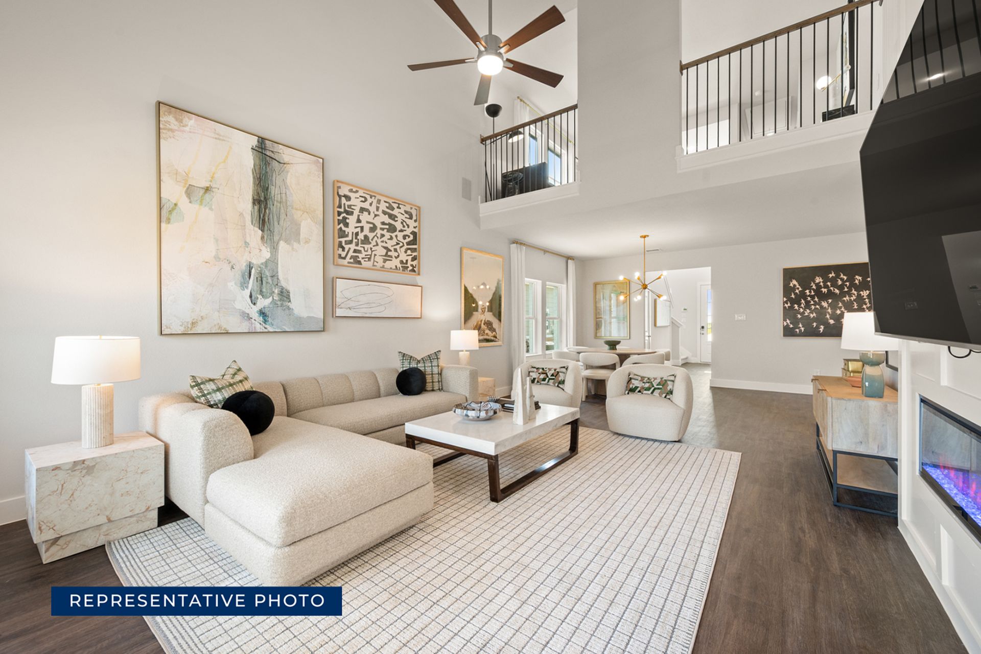 Modern living room with high ceiling, elegant decor, and cozy seating area.