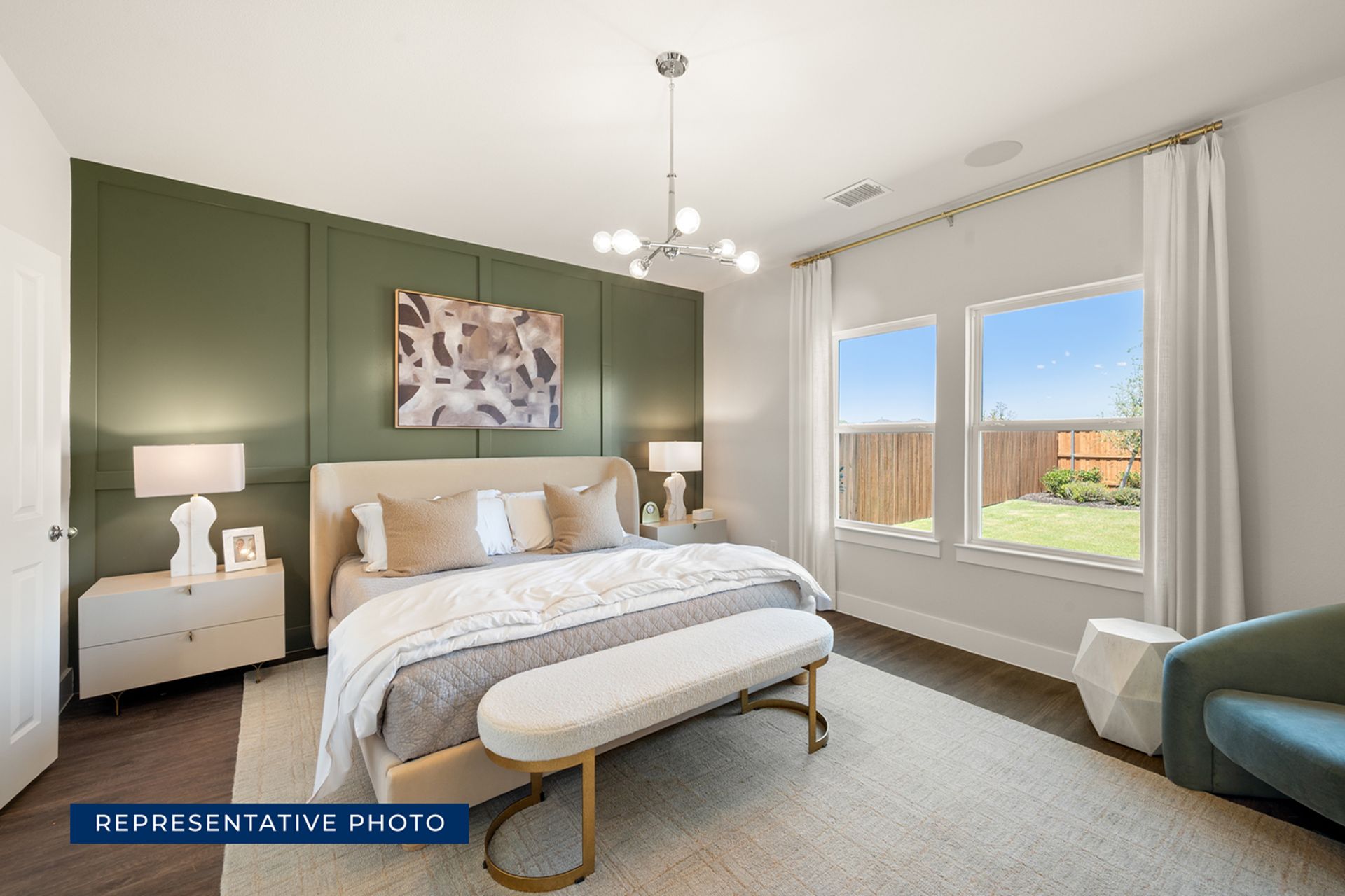 Modern bedroom with green accent wall, large windows, and stylish furniture.