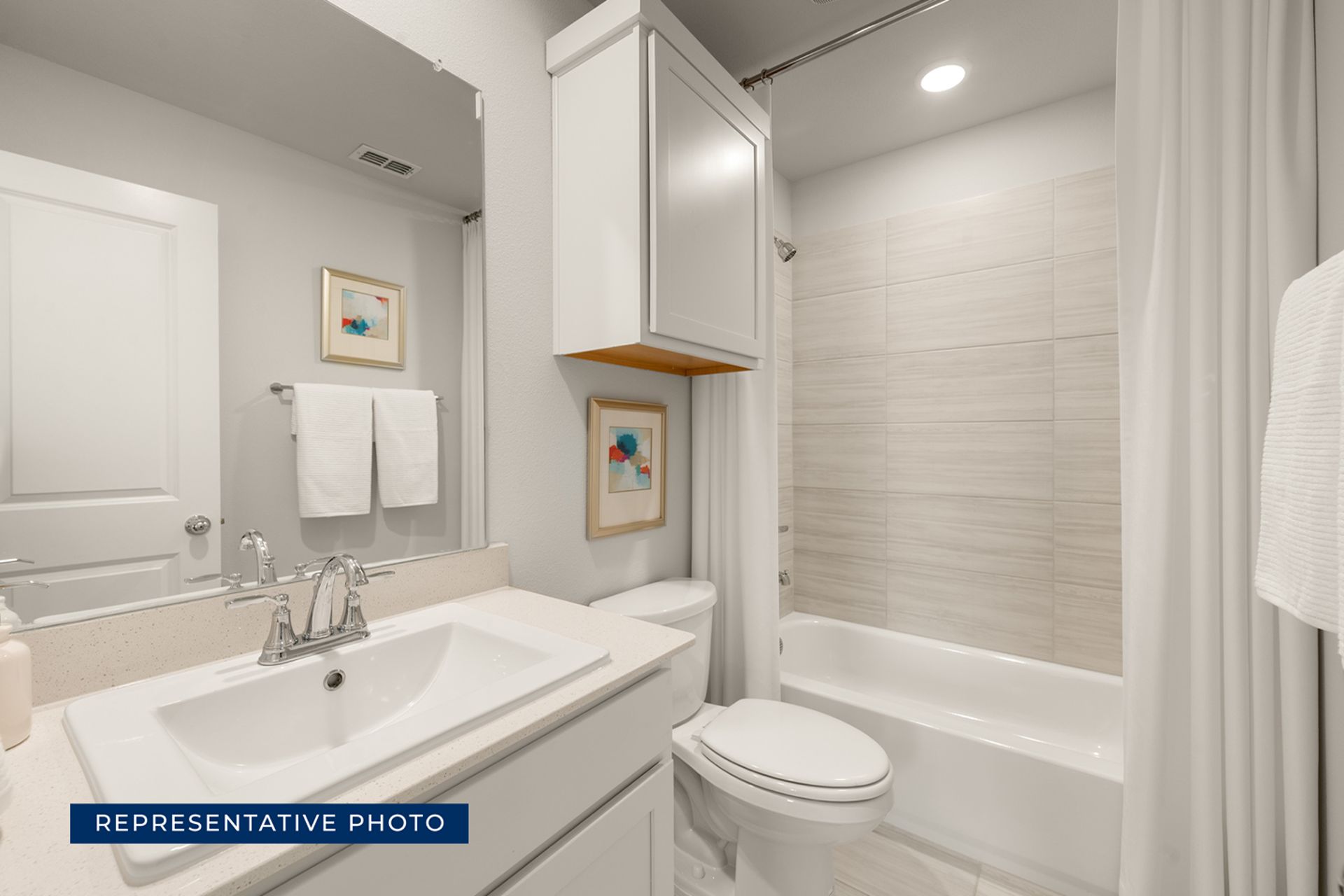 Modern bathroom with white fixtures and bathtub.