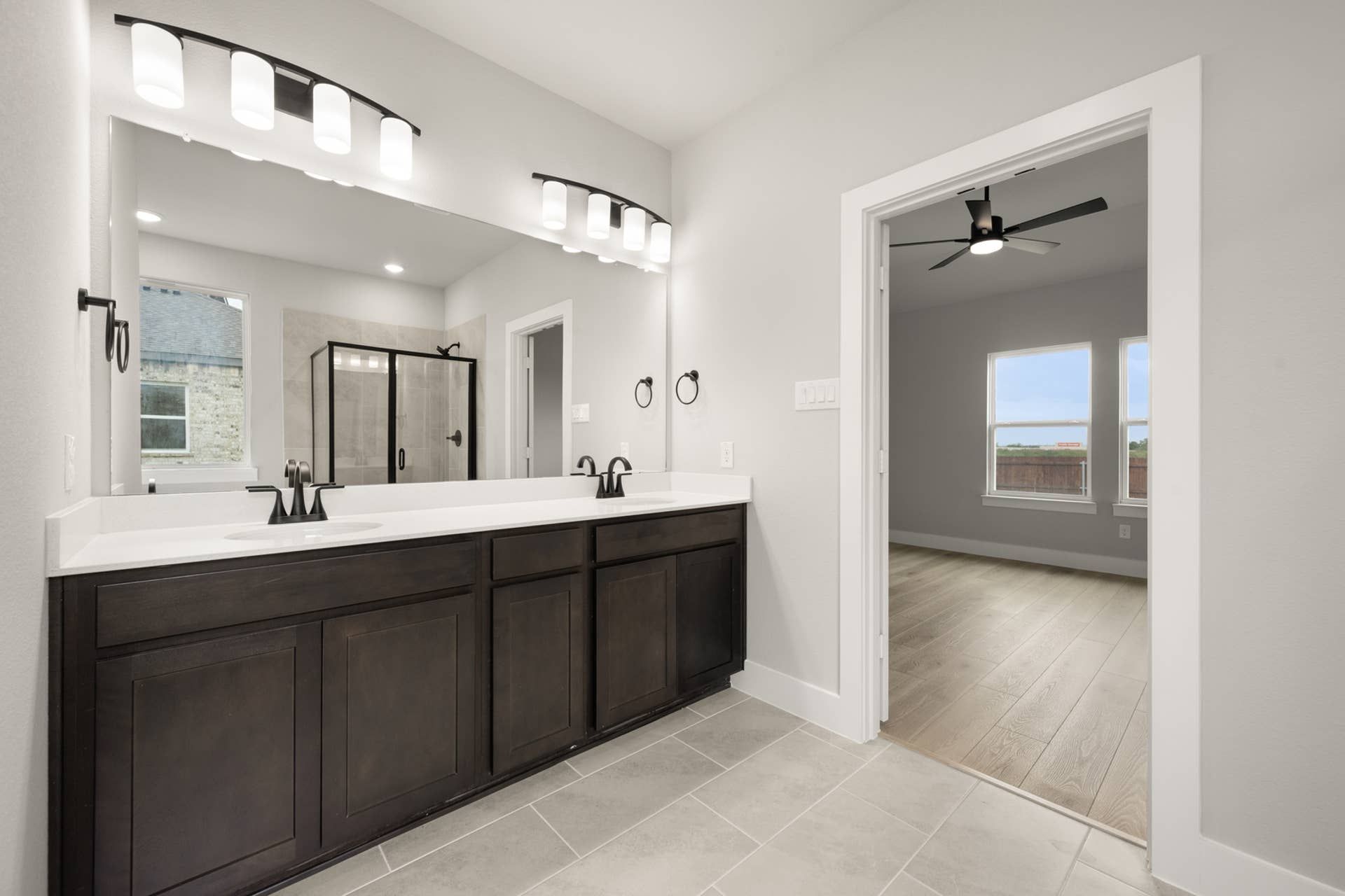 Modern primary suite bathroom with dual sinks and walk-in shower.