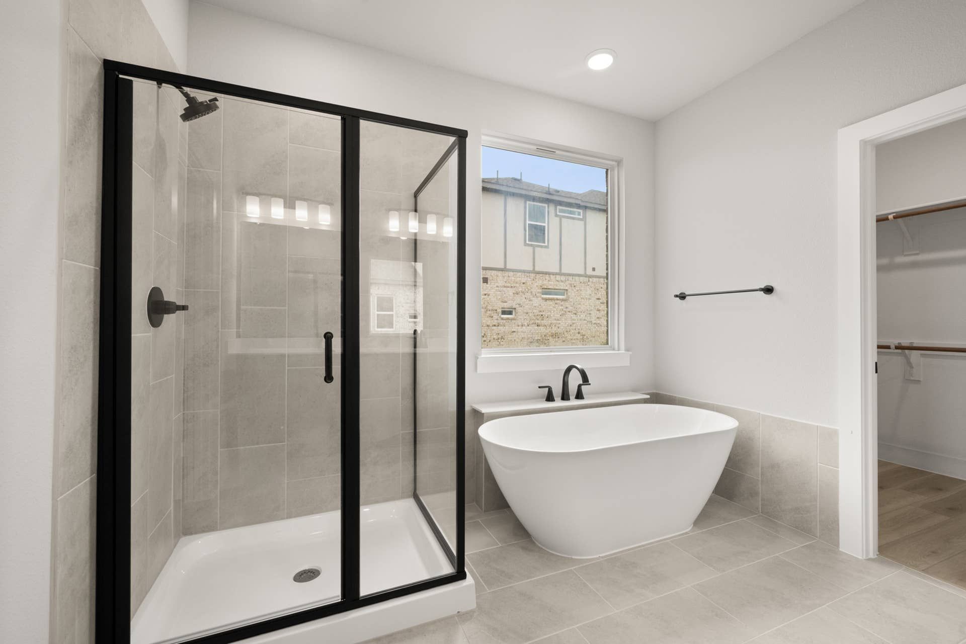 Modern bathroom with glass shower, freestanding tub, and natural light.