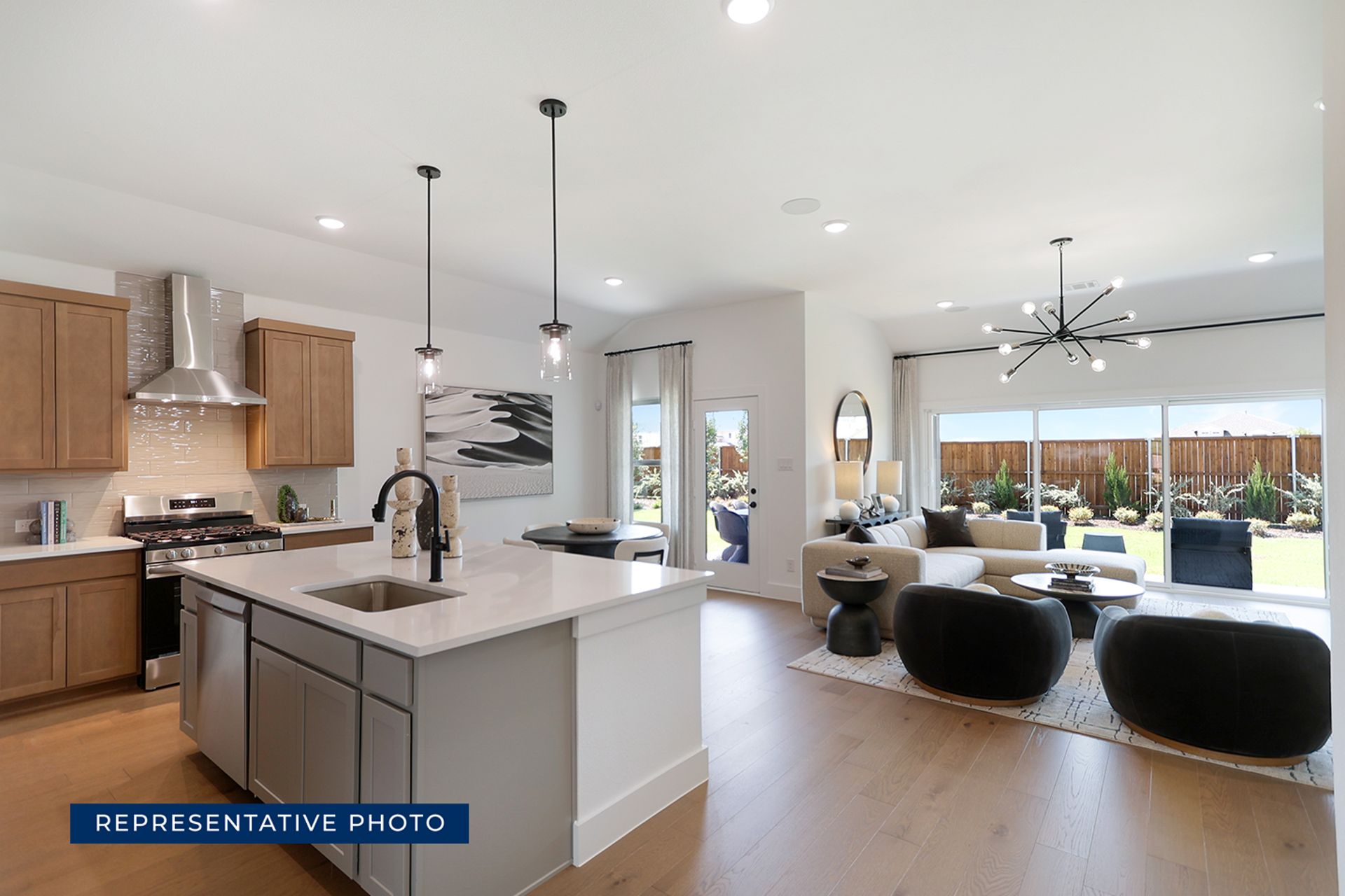 Modern kitchen and living room with large windows and stylish decor.