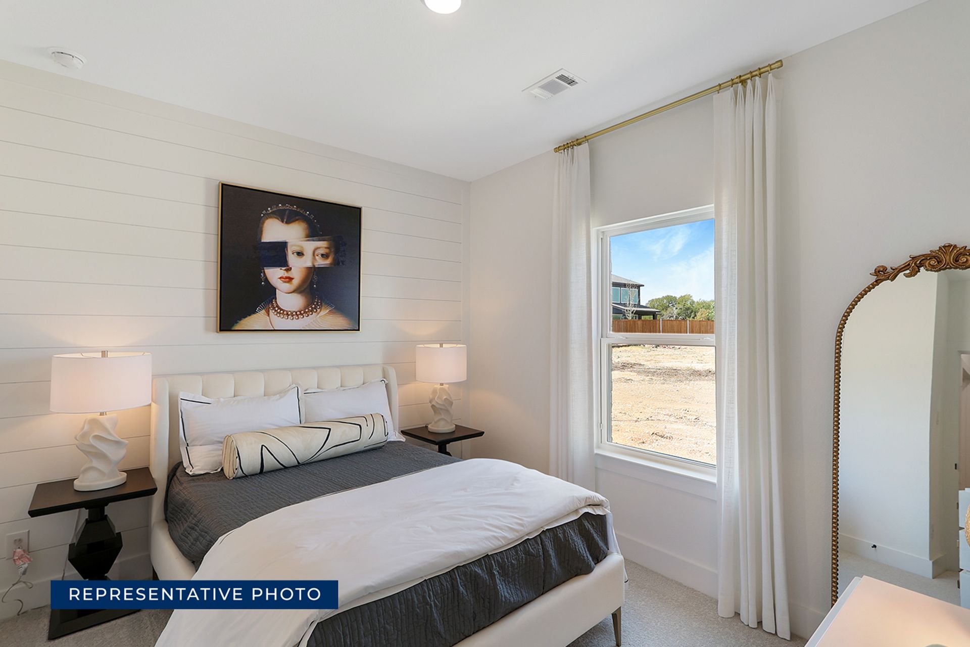 Bright bedroom with modern art, large window, and elegant decor.