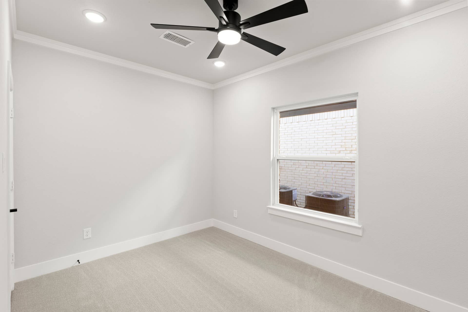 Bright study room with ceiling fan and window view.