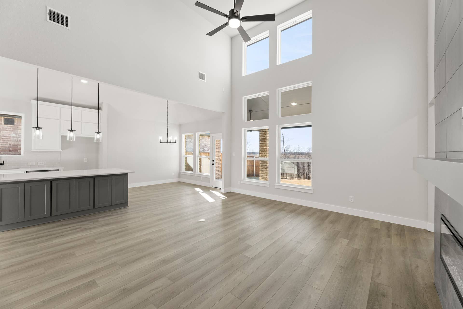 Spacious open-concept living area with high ceilings and large windows.