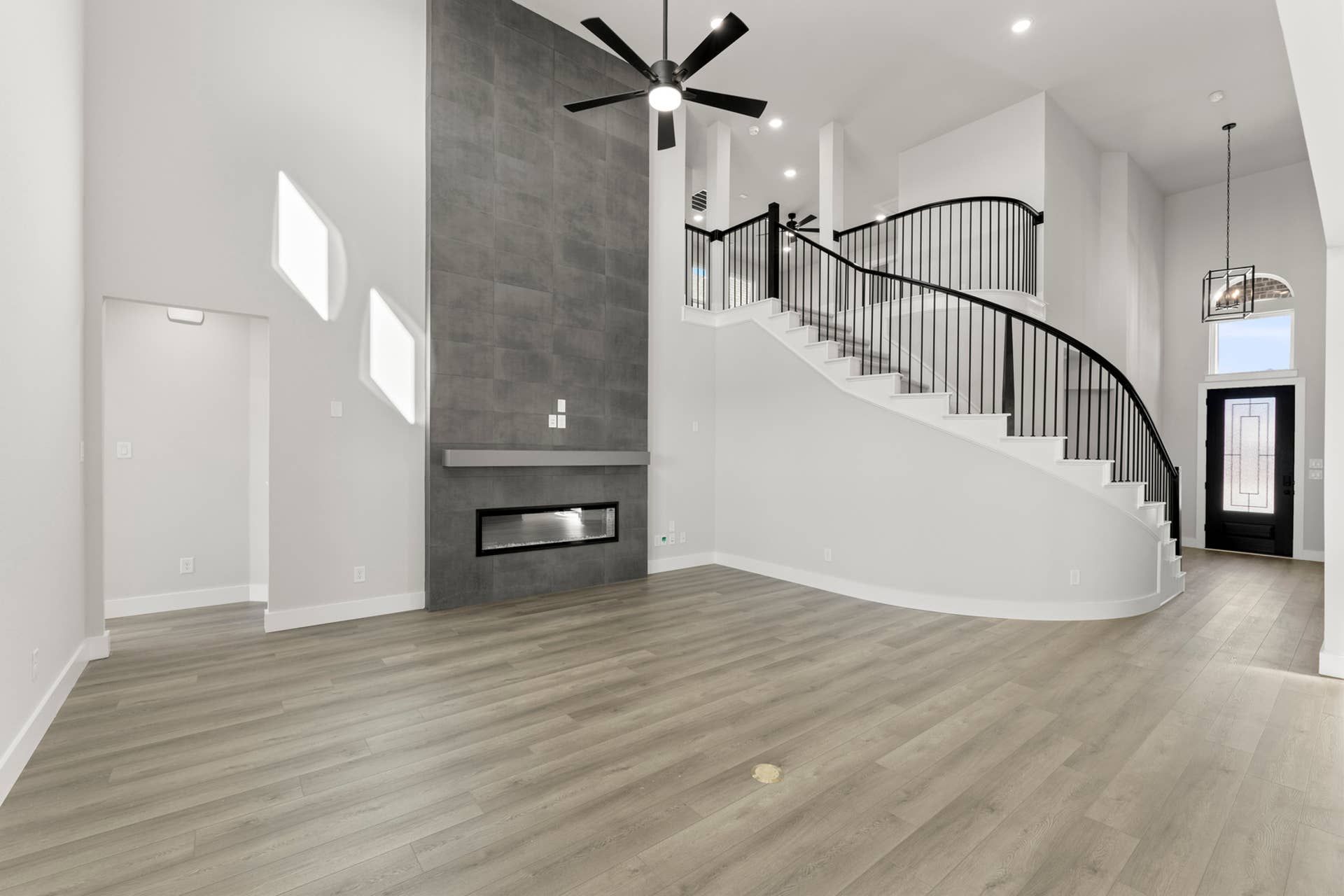 Modern living room with sleek fireplace and elegant curved staircase.