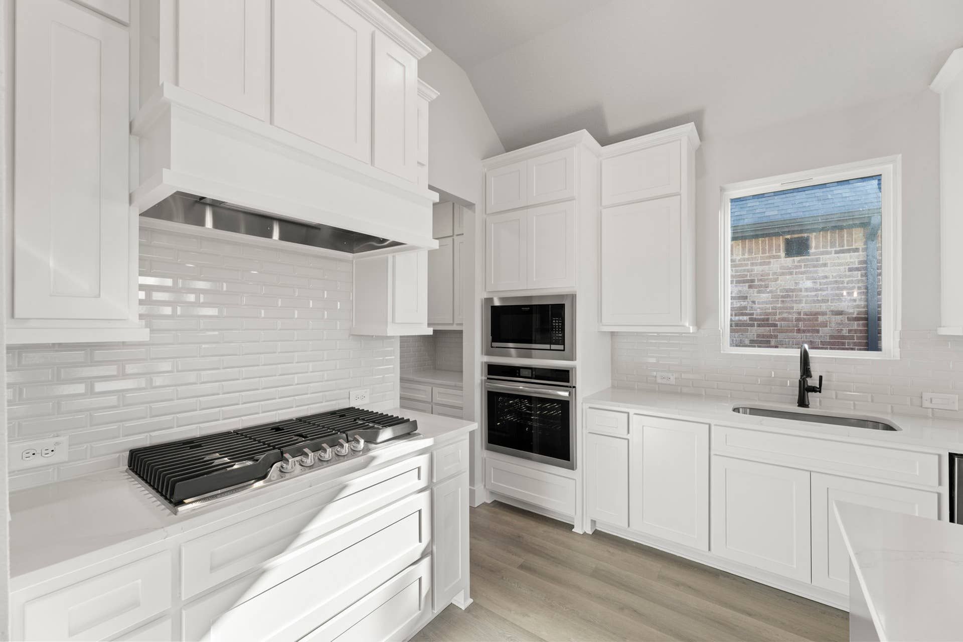 Modern kitchen with white cabinetry and stainless steel appliances.