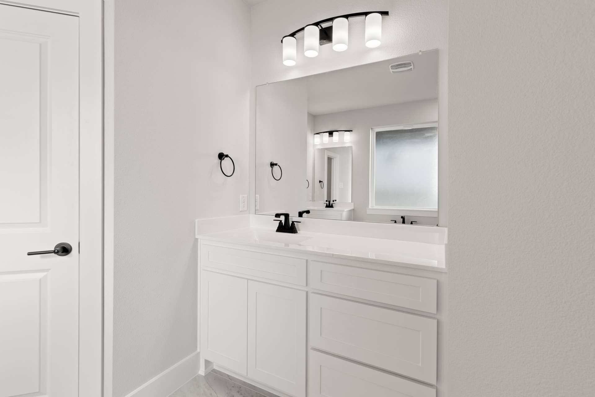 Bright modern bathroom with white vanity and large mirror.