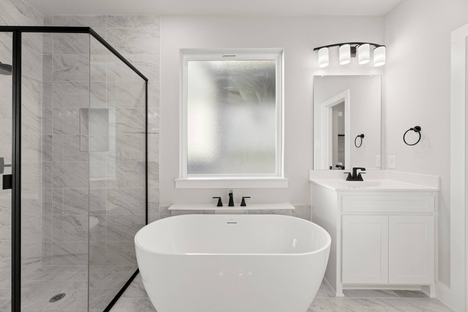 Modern bathroom with freestanding tub, glass shower, and sleek vanity.