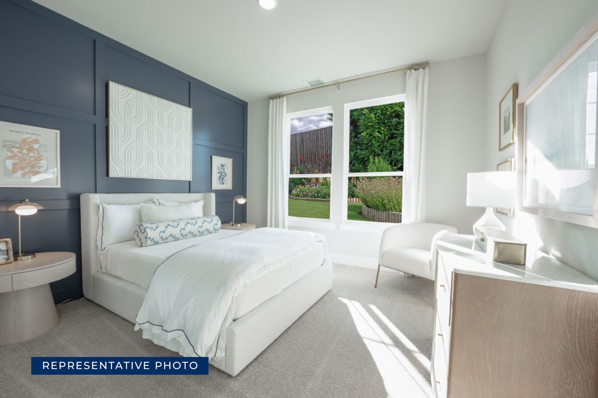Representative photo of a modern bedroom with navy accent wall and garden view.