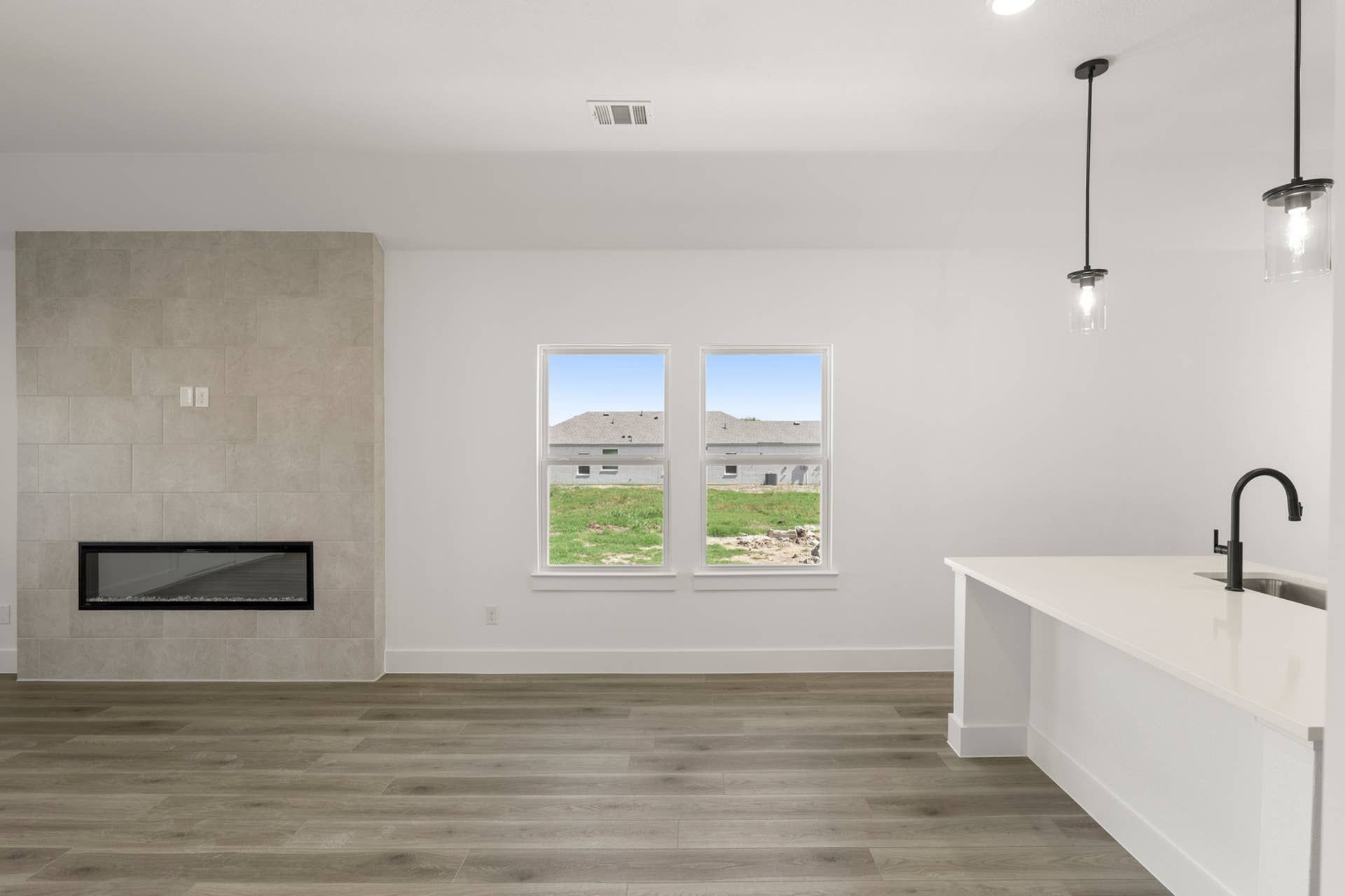 Modern dining area with fireplace, pendant lights, and large windows.