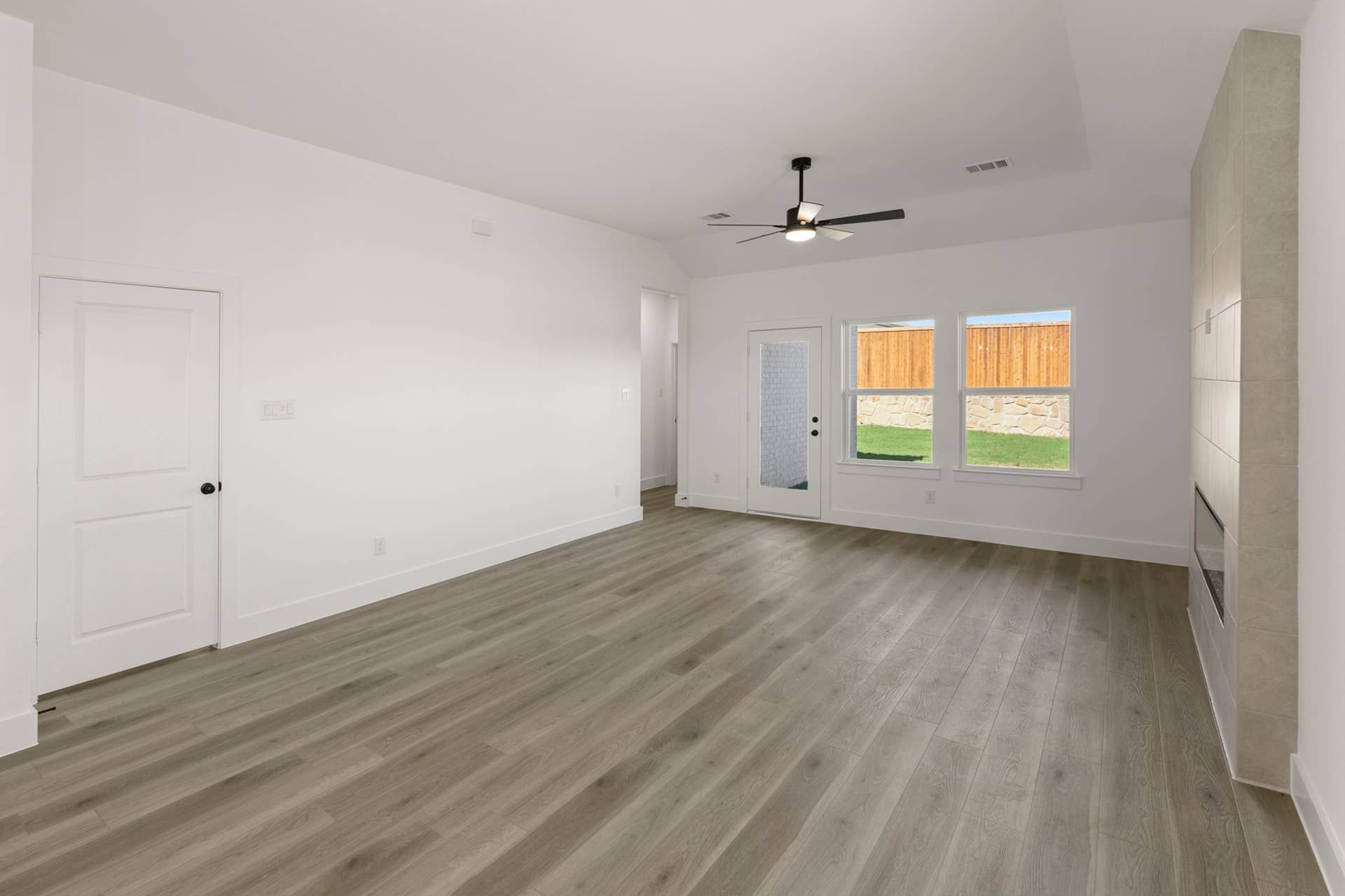 Spacious dining area with hardwood floors, ceiling fan, and natural light.