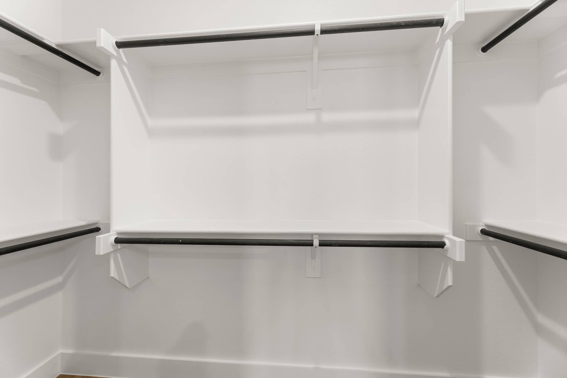 Spacious walk-in closet with multiple hanging rods and shelves.