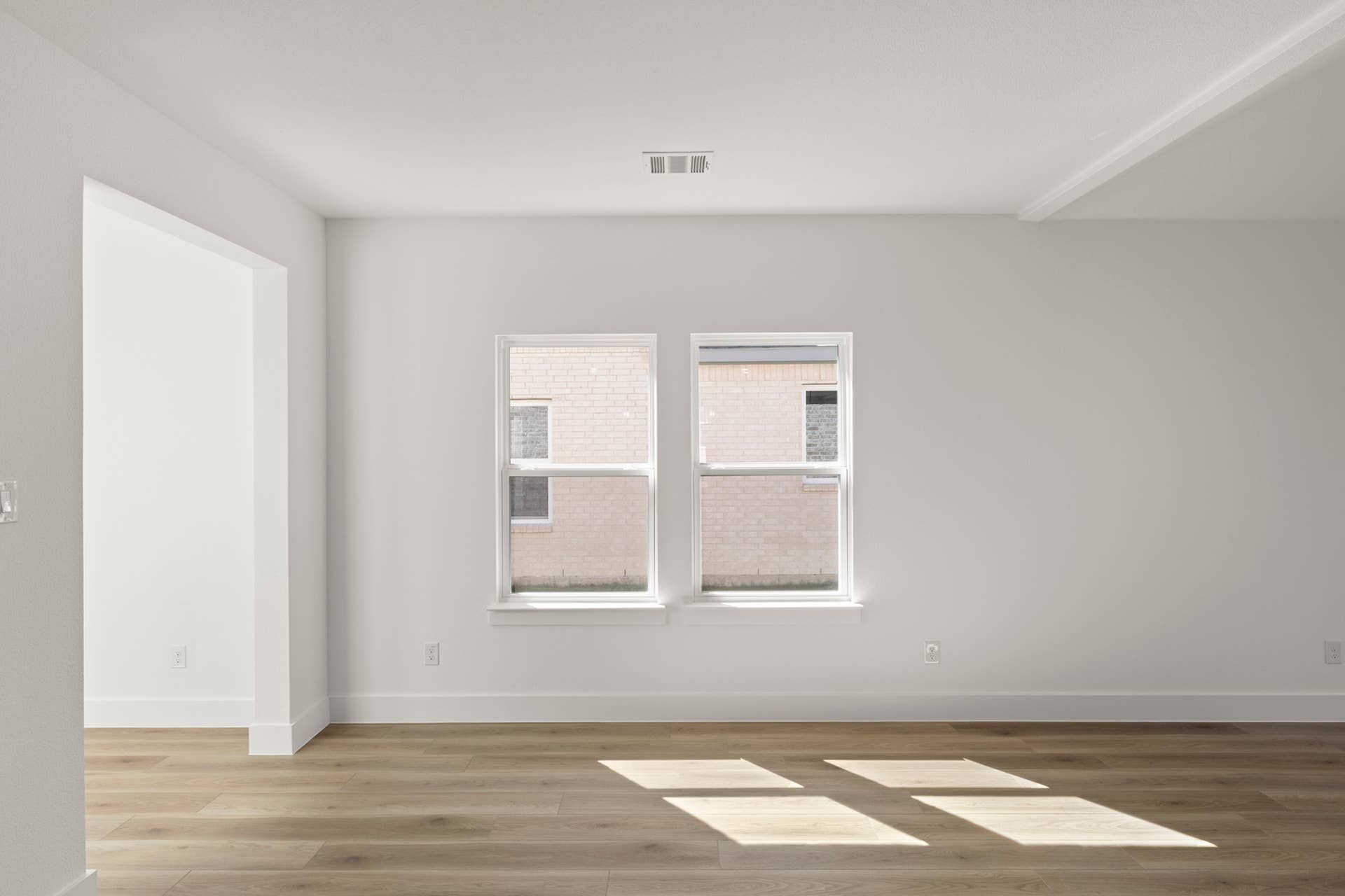 Bright dining area with large windows and hardwood floors.