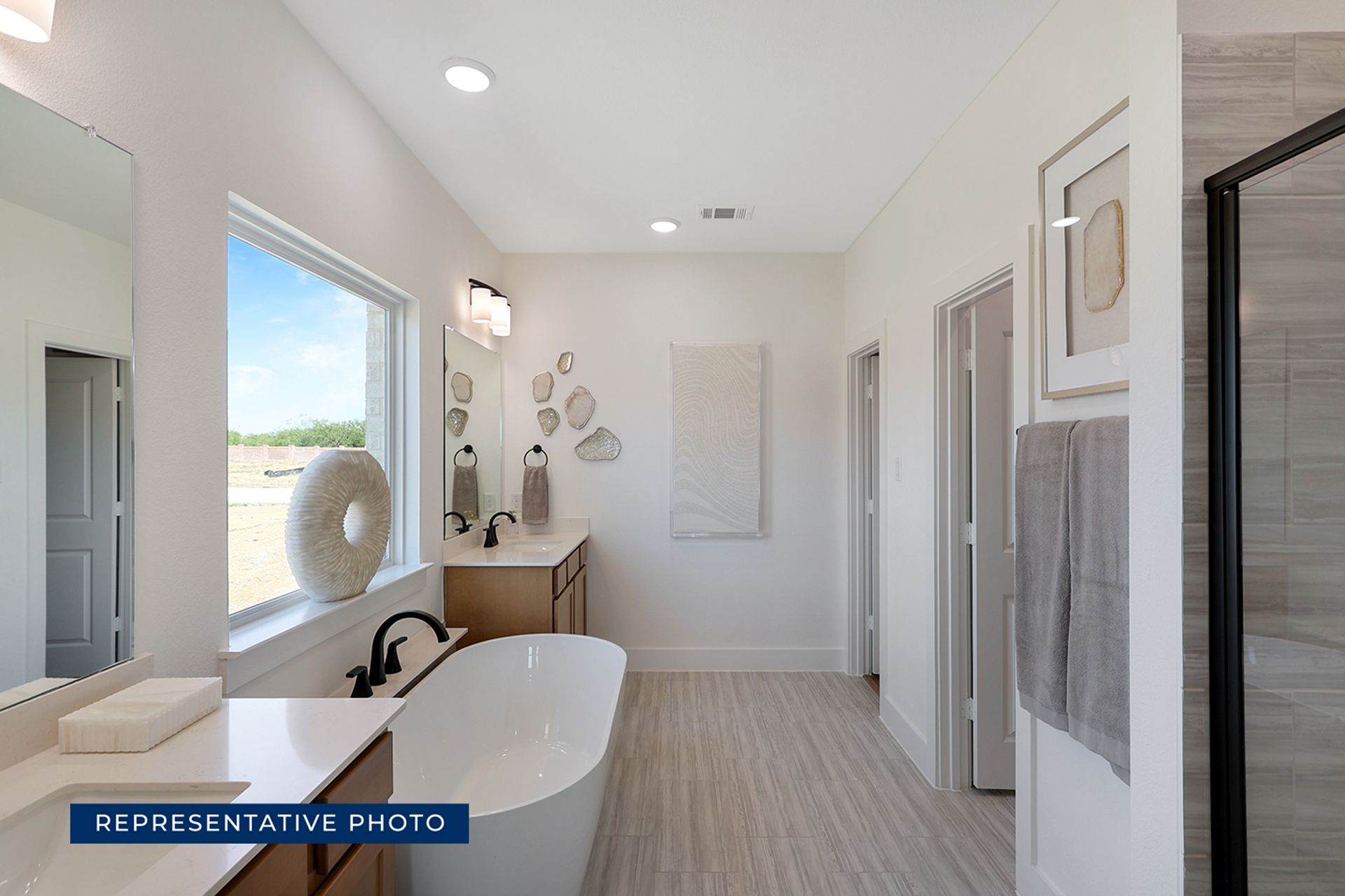 Representative photo of modern bathroom with freestanding tub and dual vanity.