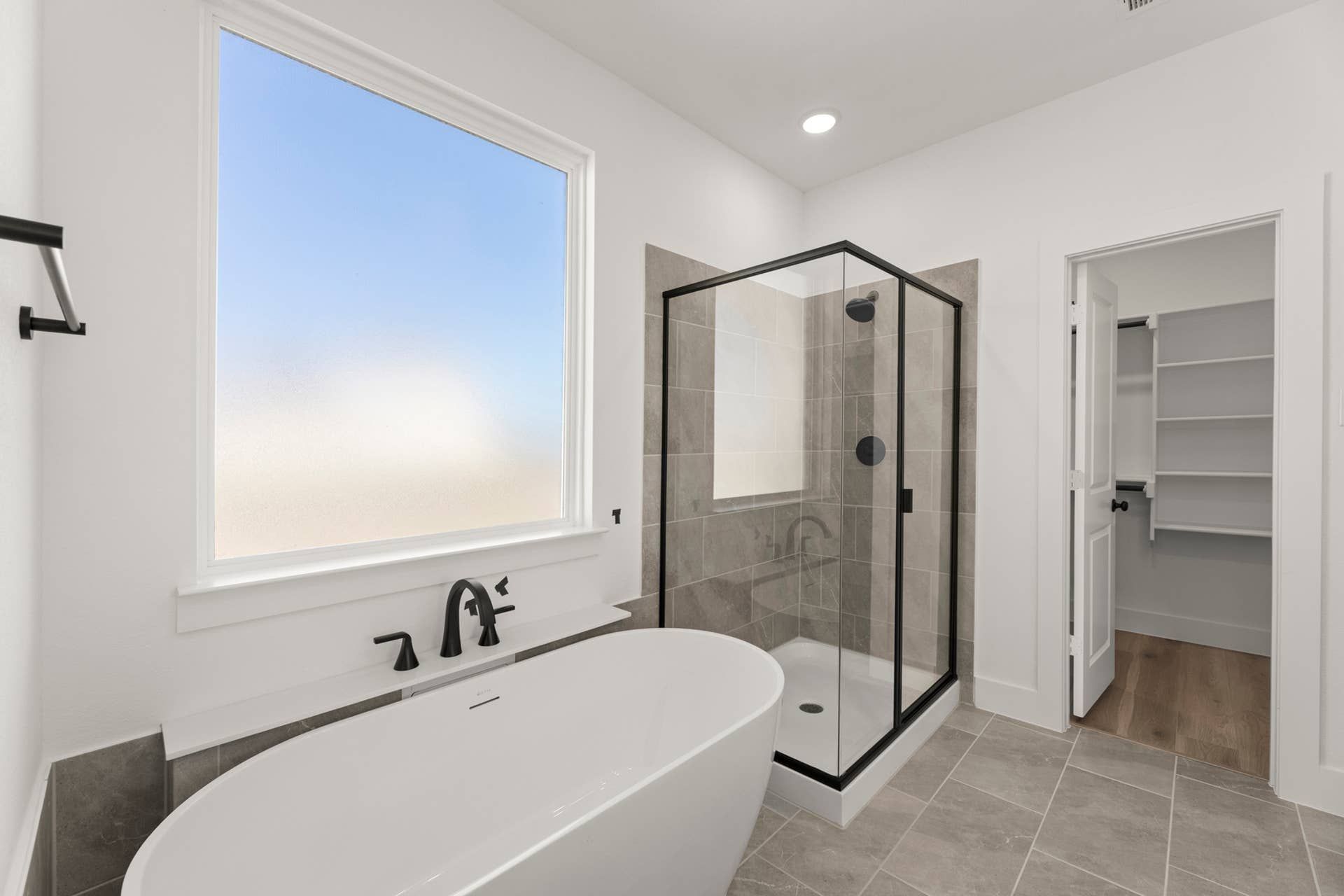 Modern bathroom with freestanding tub and glass-enclosed shower.