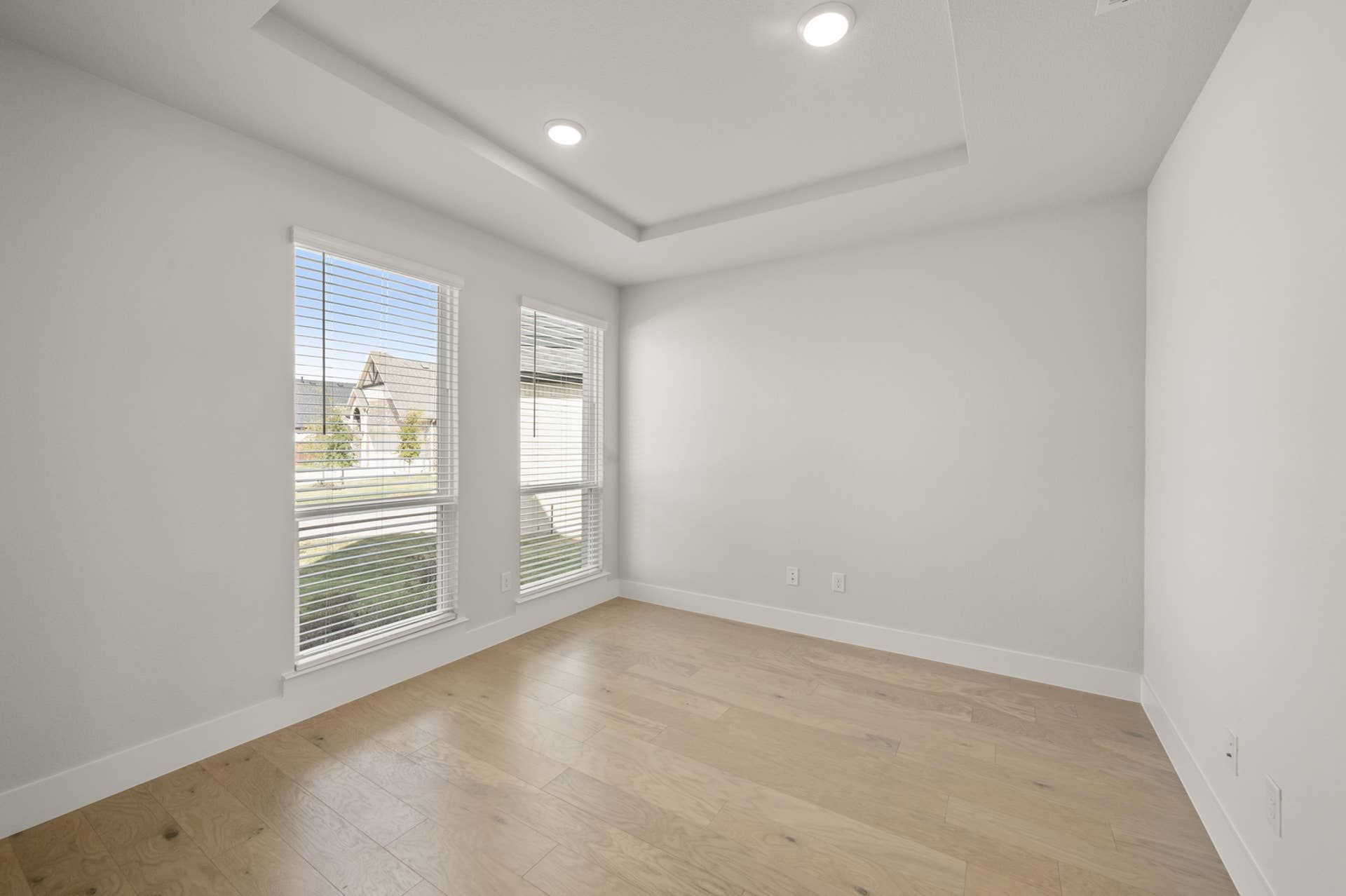 Bright flex space with large windows and wood flooring.