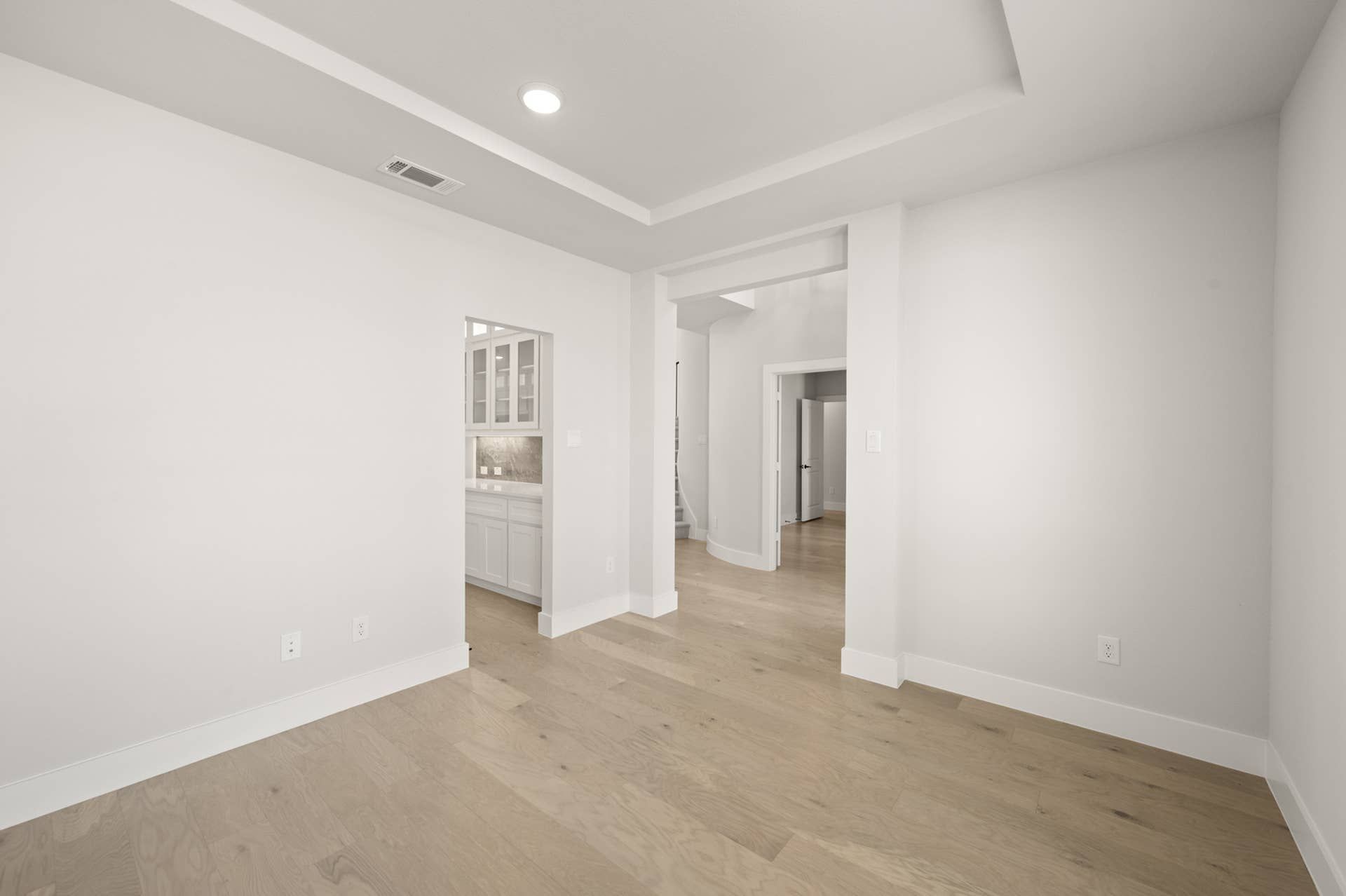 Spacious interior with hardwood floors and recessed lighting in a modern flex space.
