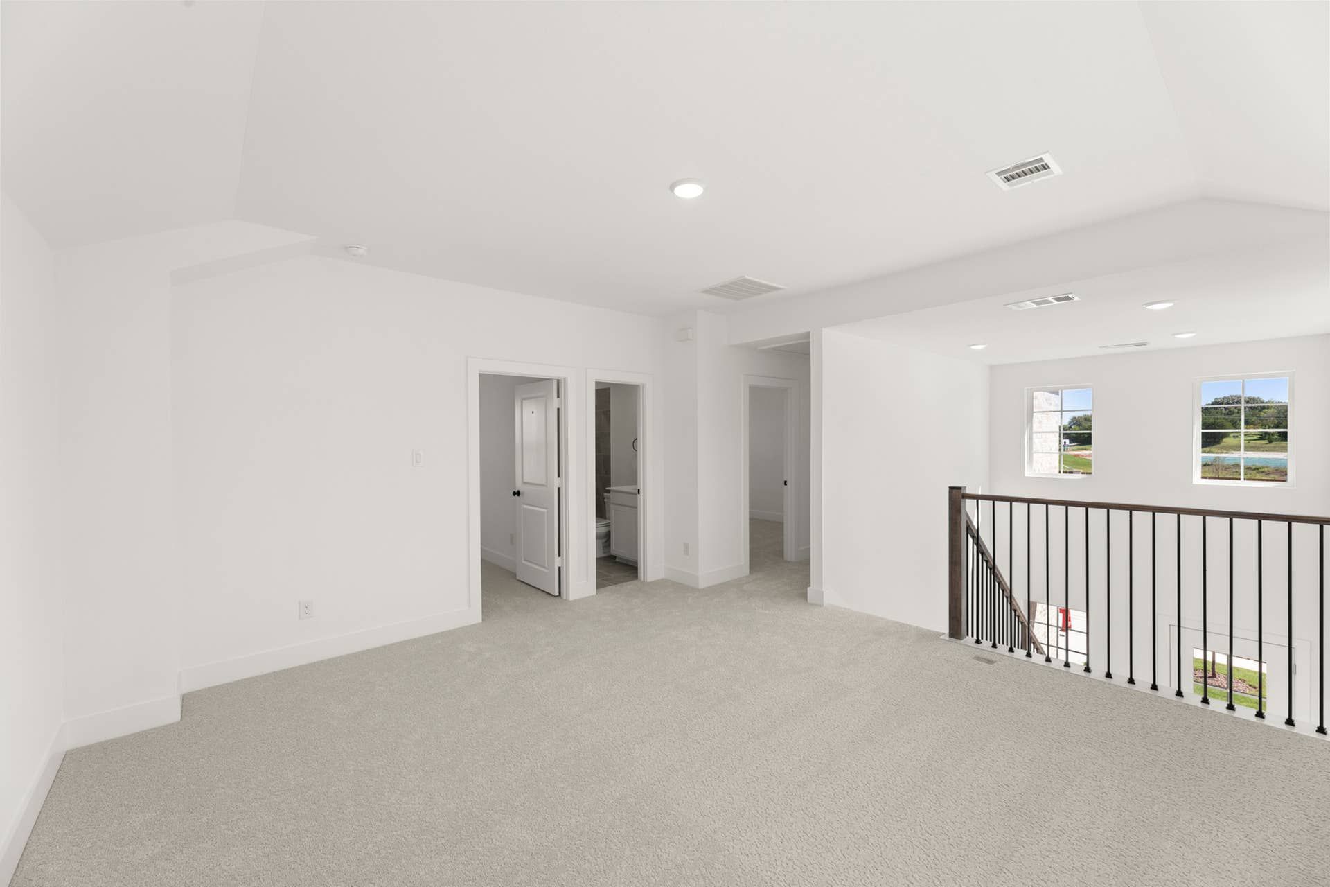 Spacious interior with neutral carpet, bright windows, and open hallway view.