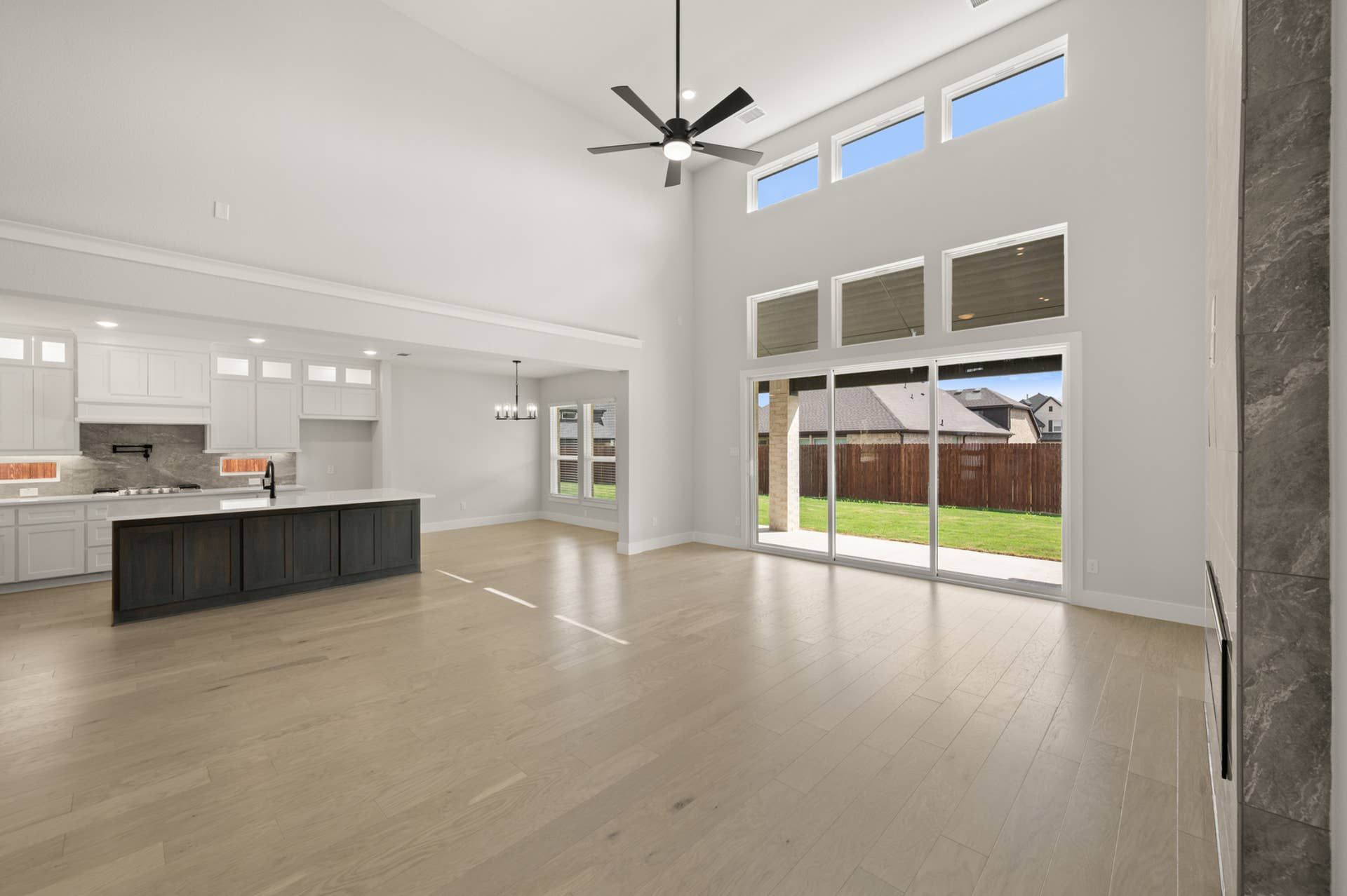Spacious living room with vaulted ceiling and large windows overlooking the backyard.