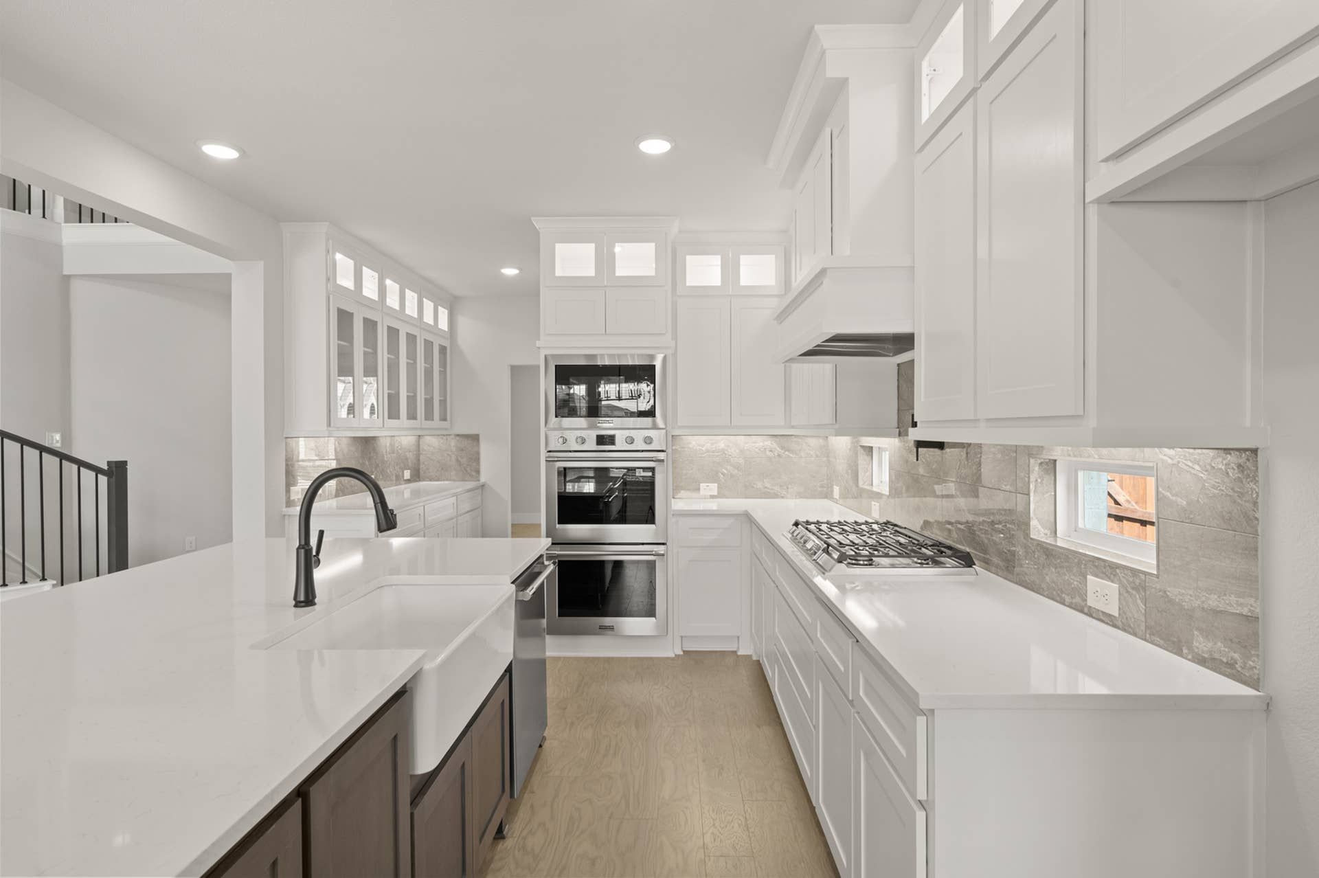 Modern kitchen with white cabinetry, farmhouse sink, and stainless steel appliances.