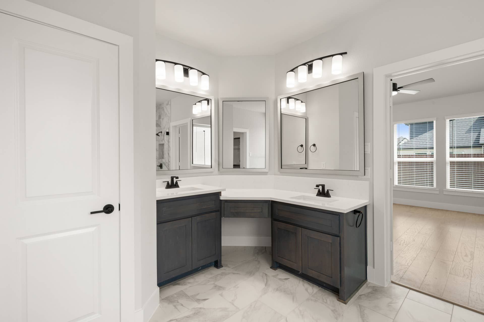 Elegant bathroom with dual sinks, large mirrors, and modern lighting in primary suite.
