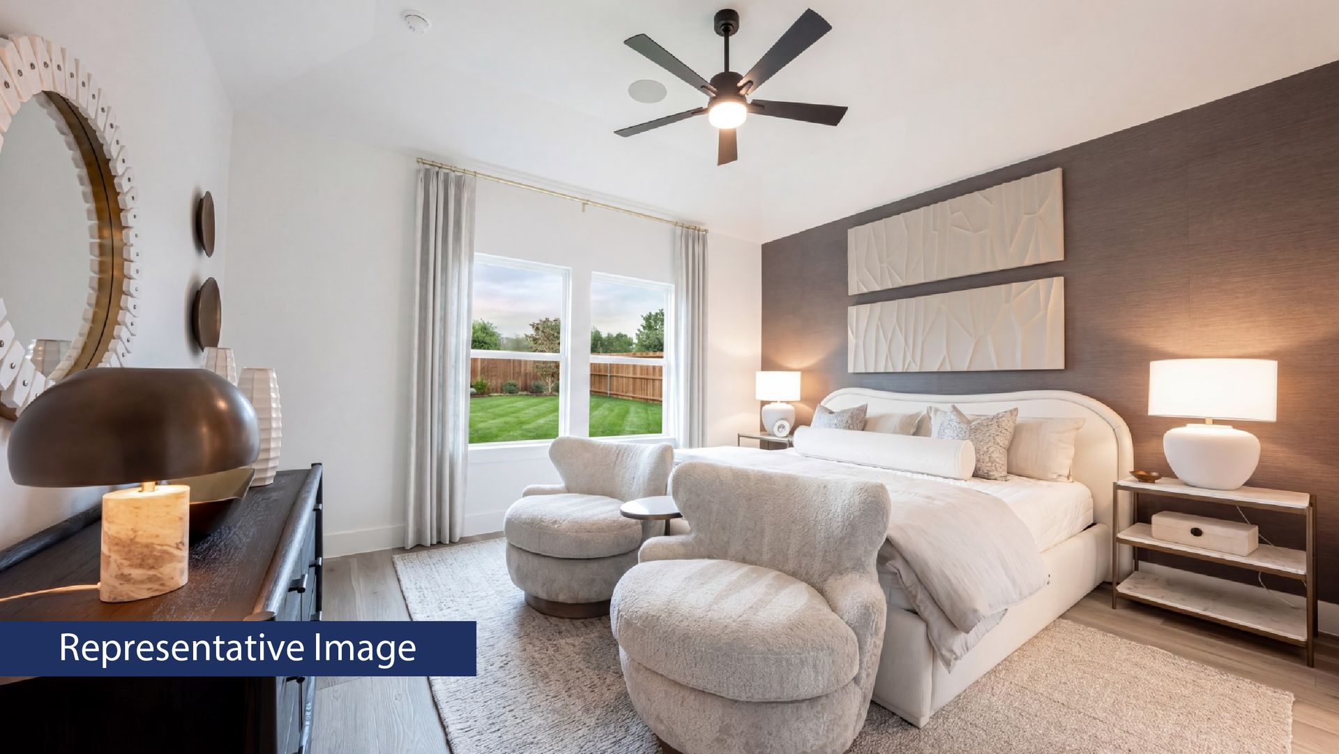 Modern bedroom with cozy seating, large bed, and elegant decor.