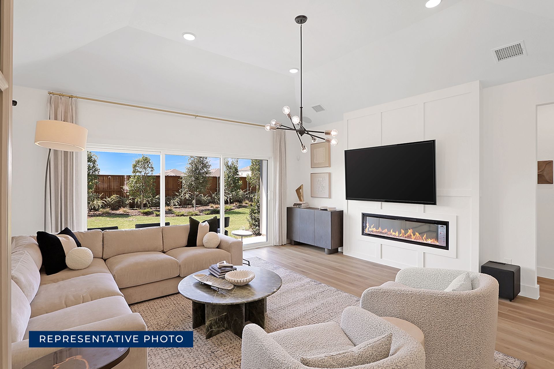 Modern living room with fireplace, large windows, and stylish furniture.