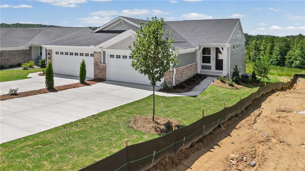 Contemporary ranch-style residence featuring a dual-bay garage, light brick and siding exterior, and dark shingle roofing