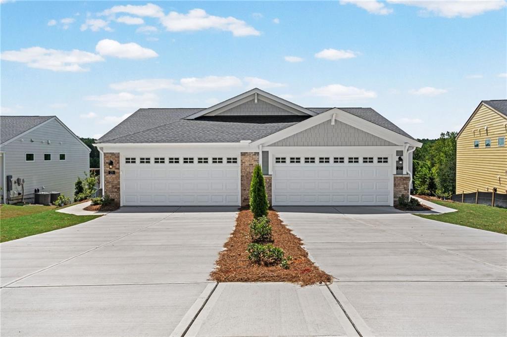 Contemporary exterior with shingled gables, stone accents, and two single-car garages
