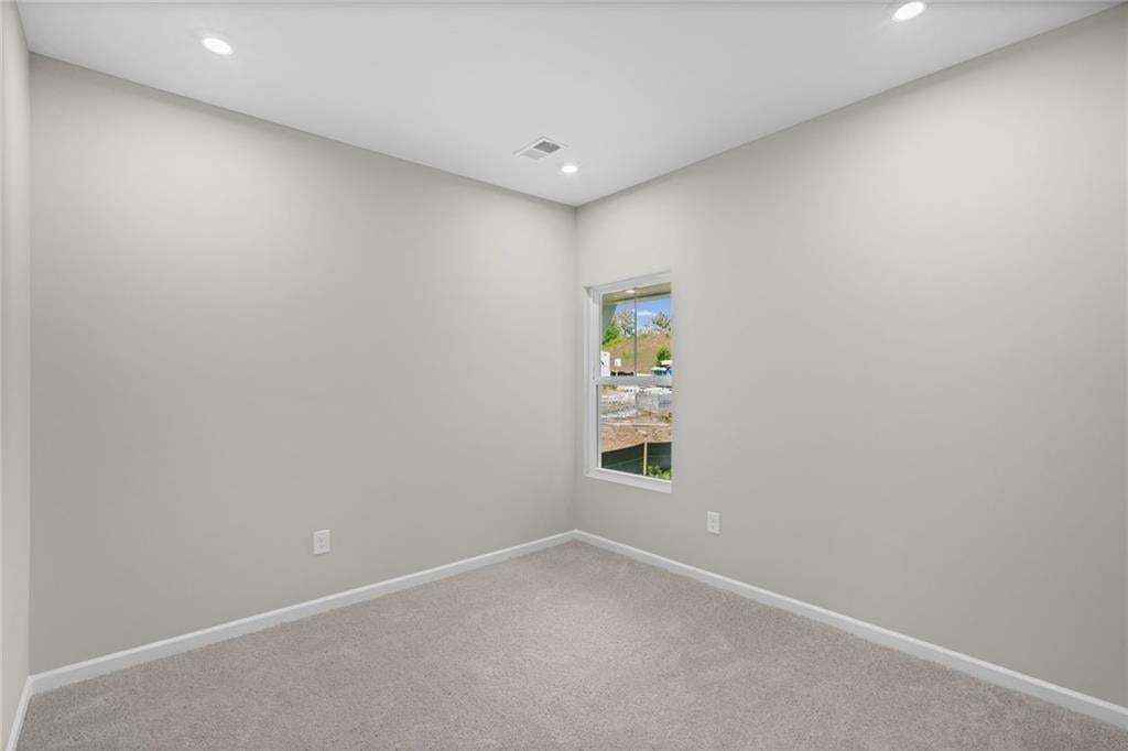 Recessed ceiling lighting, a single window, light gray wall finishes, and gray carpeting